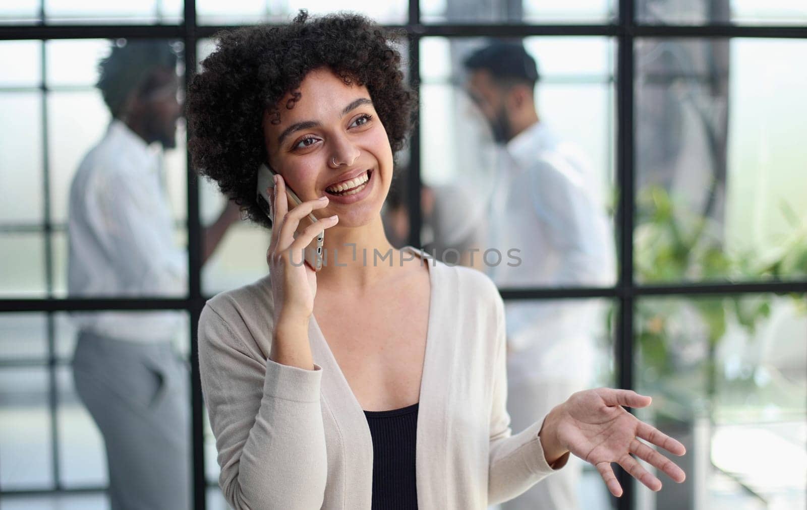 Businesswoman sitting in office, talking on the phone
