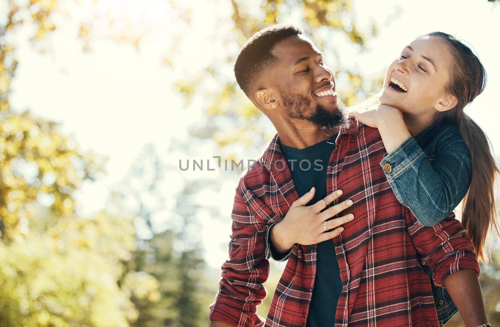 Couple, hug and smile while outdoor with love and care in nature, happy together while bonding in park. Black man, woman and interracial, hugging in relationship and marriage with romance mock up