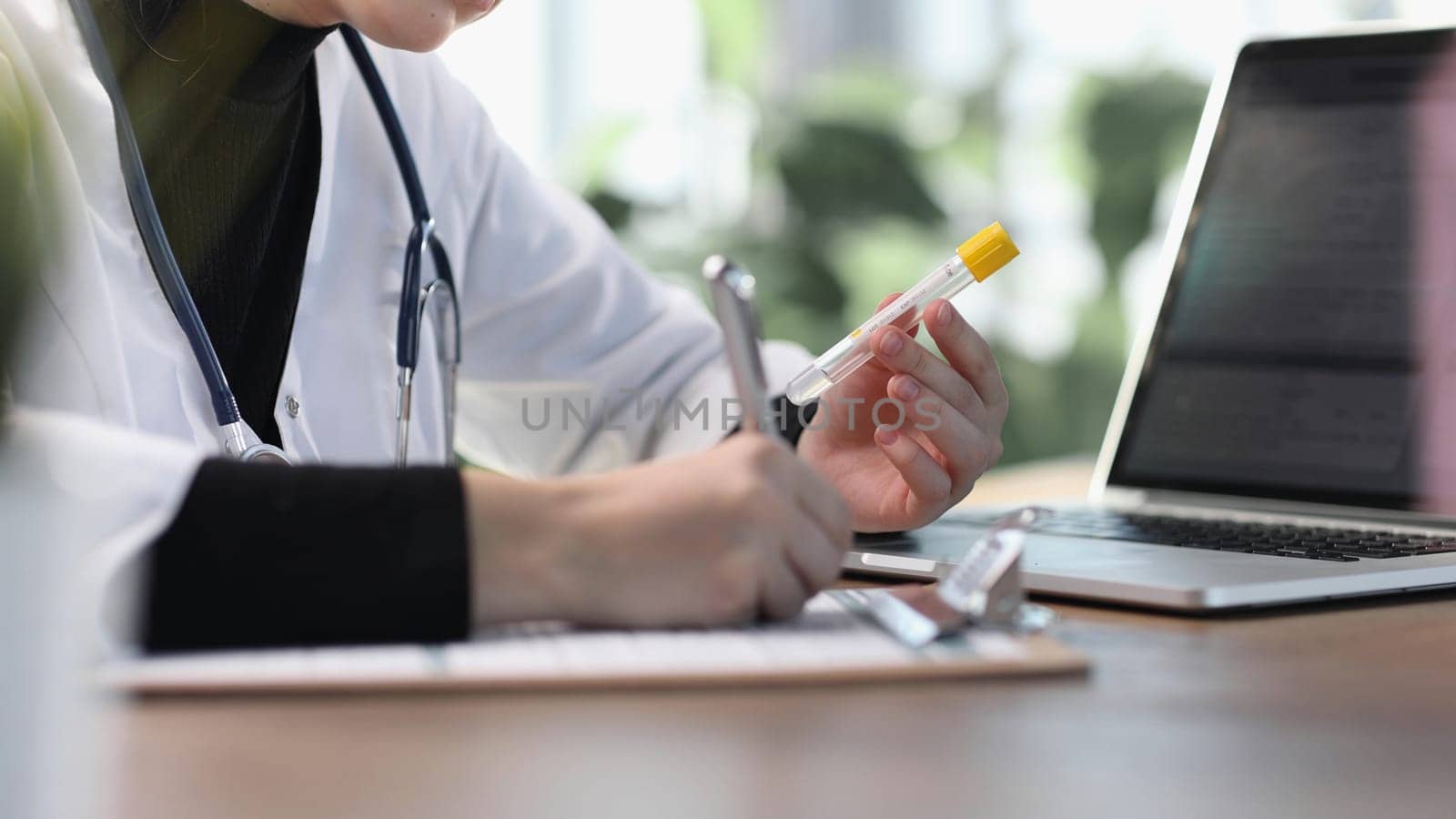 Female professional doctor hand making notes in medical journal.