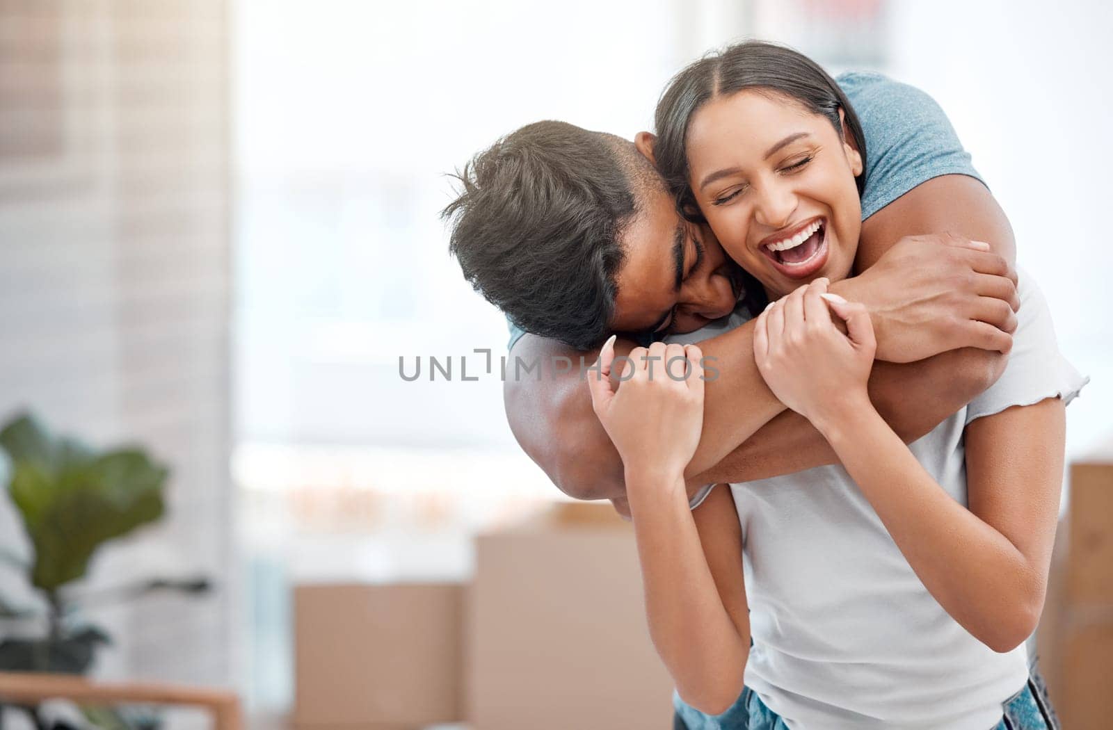 Hug, love and couple laugh in new home excited for property, apartment and real estate investment, Relationship, house and man and woman embrace, laughing and happy in living room on moving day by YuriArcurs