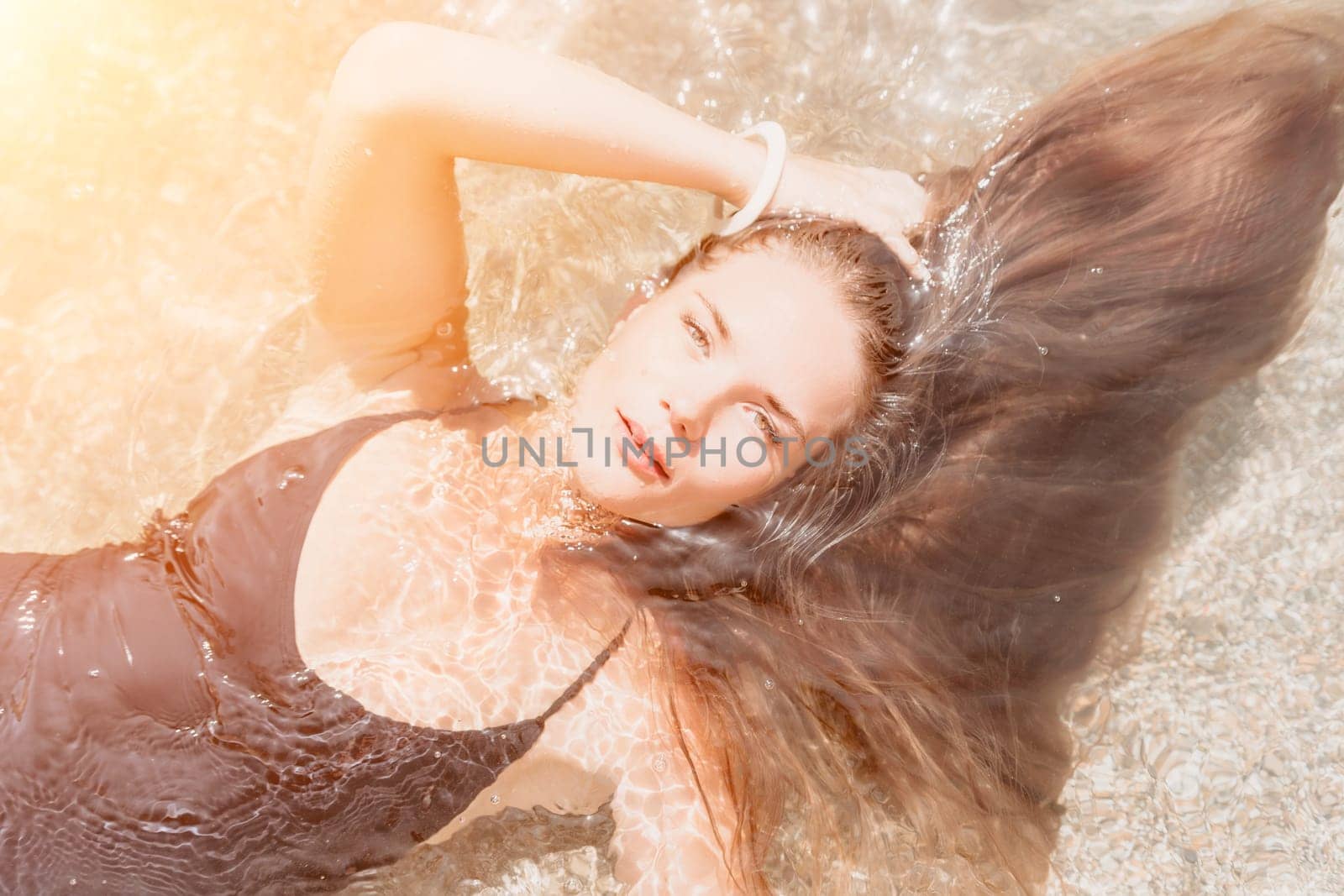 Woman travel sea. Young Happy woman in a long red dress posing on a beach near the sea on background of volcanic rocks, like in Iceland, sharing travel adventure journey