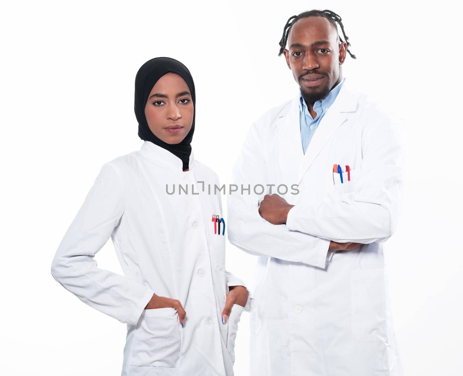 Closeup front view of group of mixed age doctors and nurses standing side by side and looking at the camera. Young Middle Eastern female in a team with African American male doctor. by dotshock