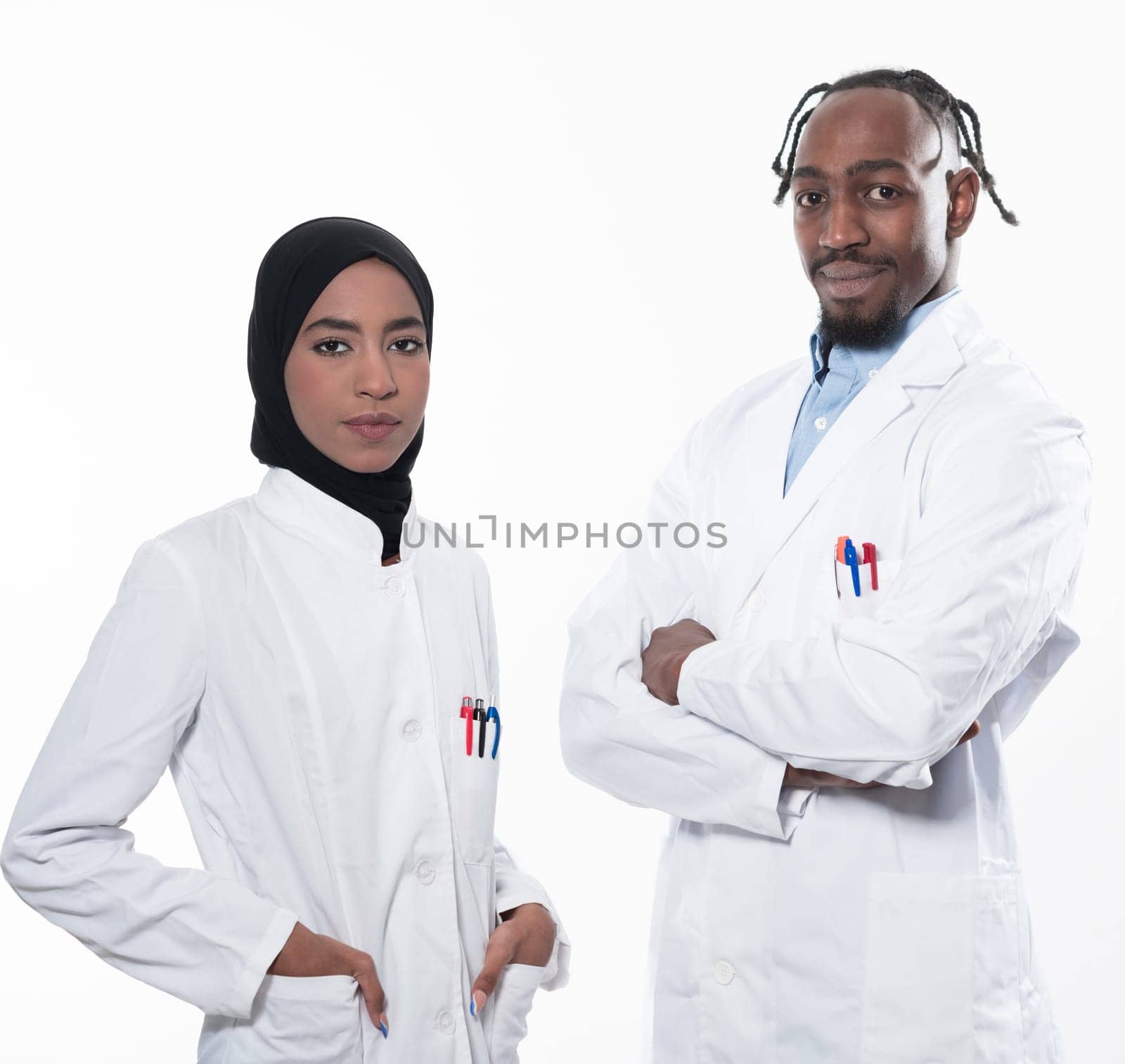 Closeup front view of group of mixed age doctors and nurses standing side by side and looking at the camera. Young Middle Eastern female in a team with African American male doctor. by dotshock