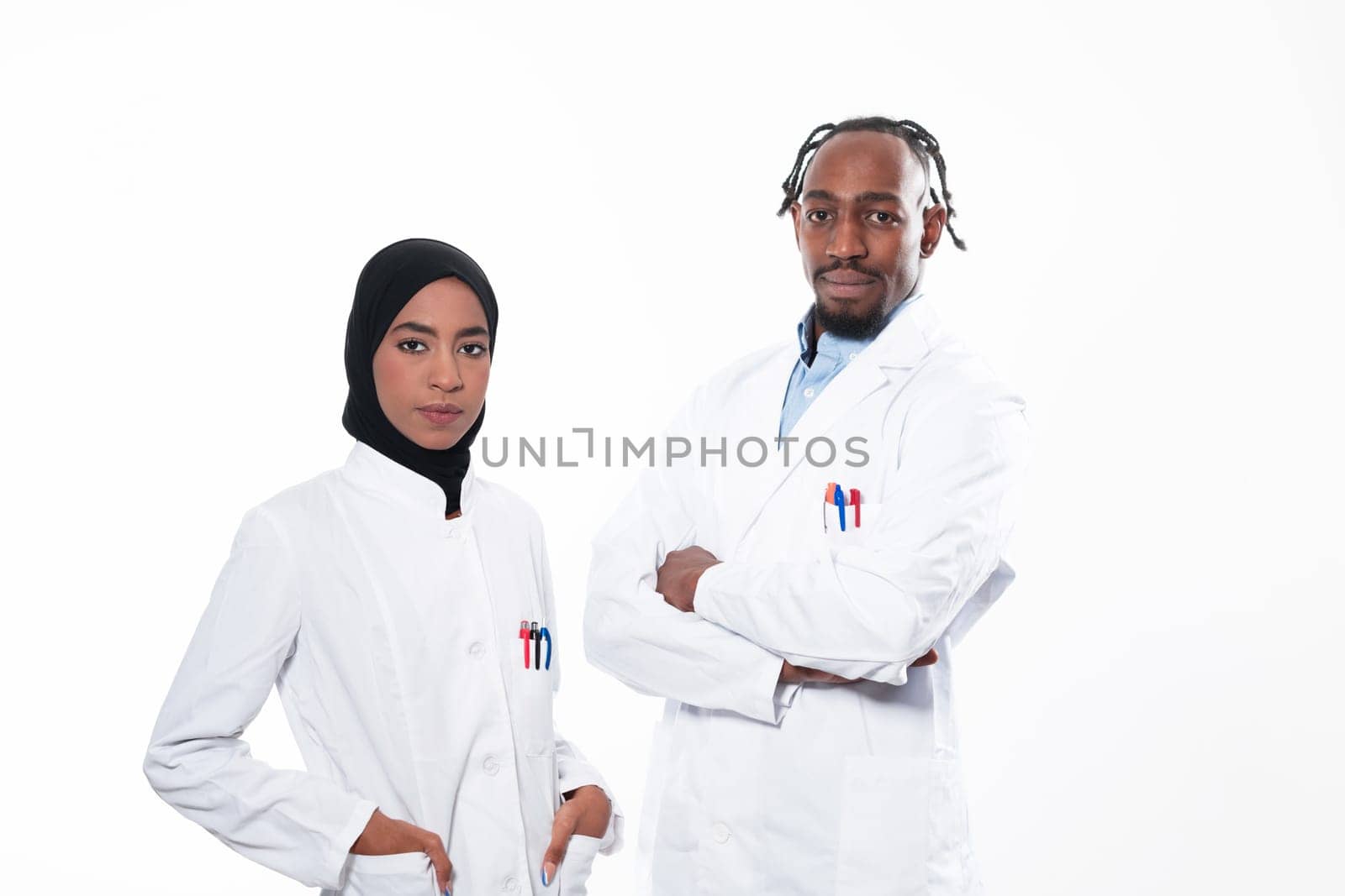 Closeup front view of group of mixed age doctors and nurses standing side by side and looking at the camera. Young Middle Eastern female in a team with African American black doctor. High quality photo