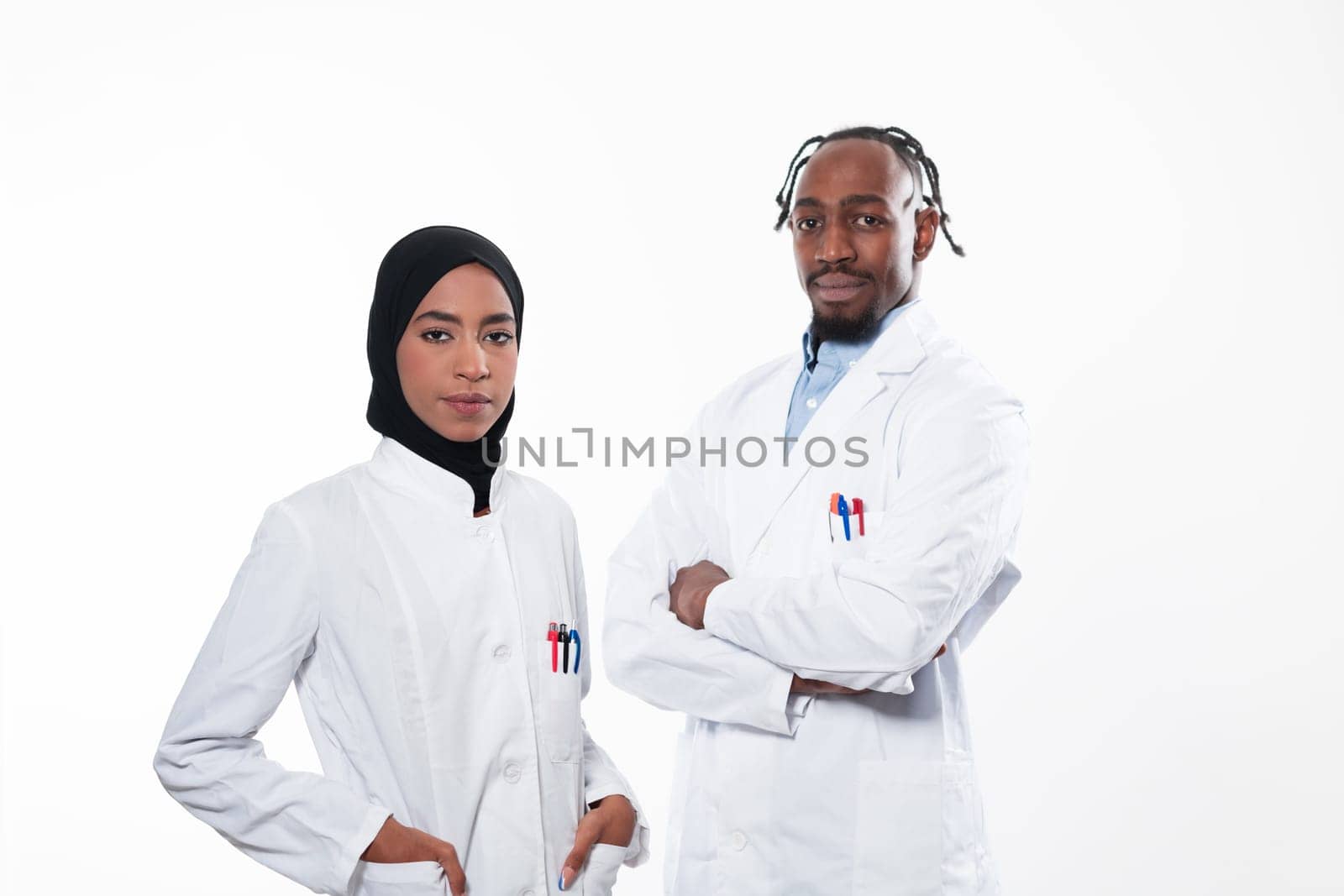 Closeup front view of group of mixed age doctors and nurses standing side by side and looking at the camera. Young Middle Eastern female in a team with African American male doctor. by dotshock