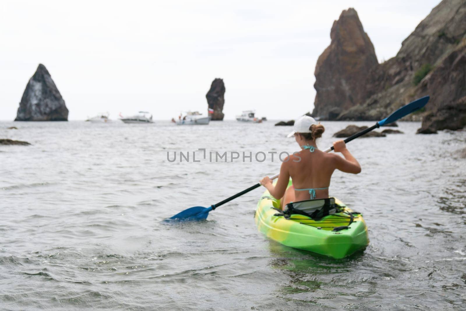 Kayaking. Travel adventure kayak on the tropical sea on a sunny day. Woman rowing a canoe.