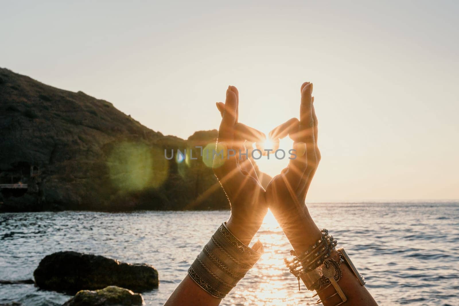 Woman sea yoga. Happy woman in white swimsuit and boho style braclets practicing outdoors on yoga mat by sea on sunset. Women yoga fitness routine. Healthy lifestyle, harmony and meditation by panophotograph