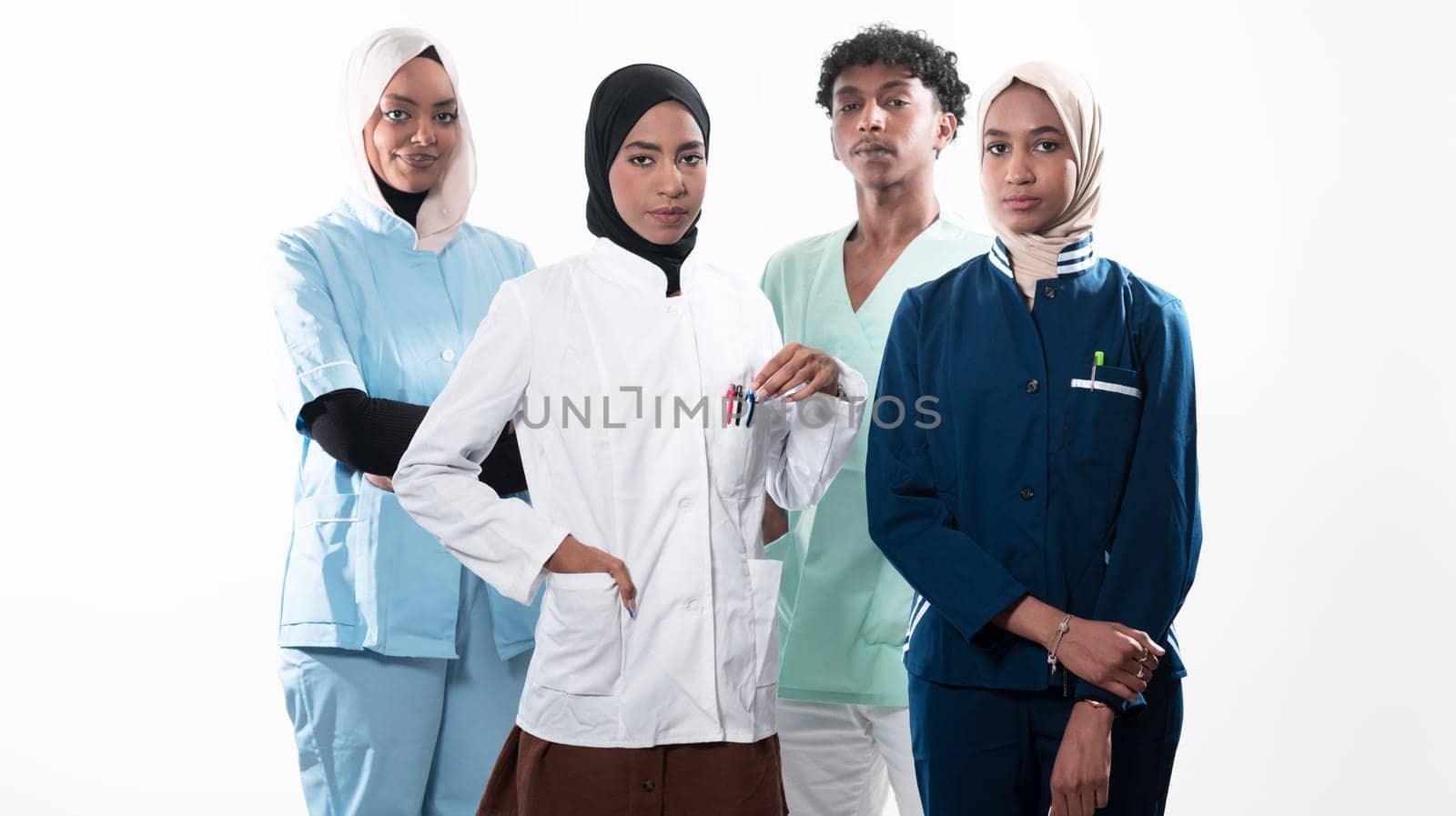 Closeup front view of group of mixed age doctors and nurses standing side by side and looking at the camera. Young Middle Eastern female in a team with African American black doctor. High quality photo