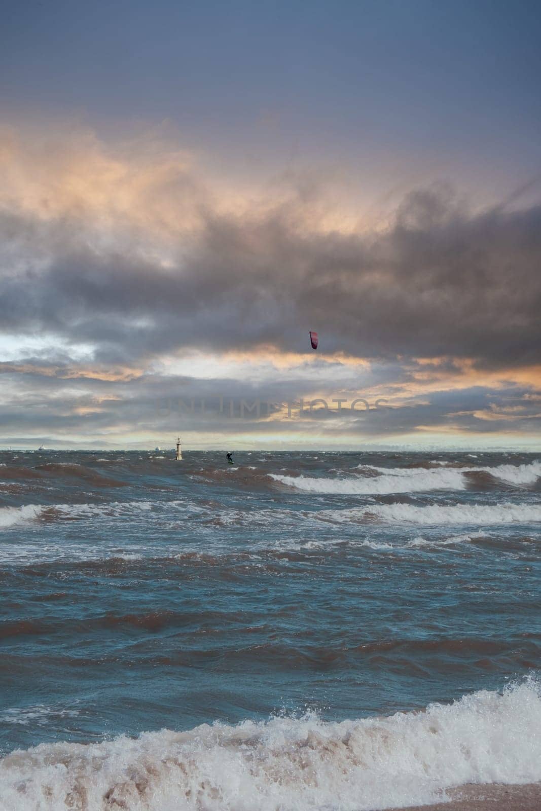 Wing Foiling kitesurfing wind surfing water outdoor sport in Baltic sea Dark blue clouds ocean water surface with foam waves before storm, dramatic seascape background.