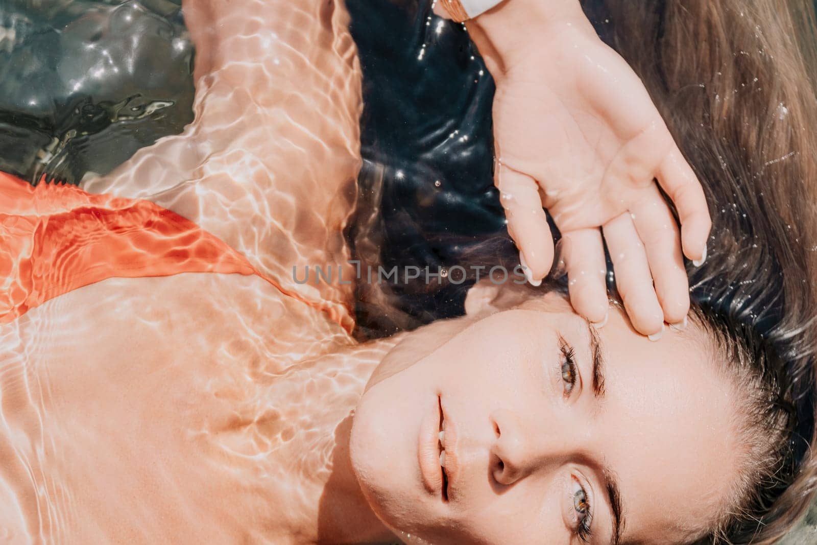 Side view a Young beautiful sensual woman in a mint long dress posing on a volcanic rock high above the sea during sunset. Girl on the nature on overcast sky background. Fashion photo