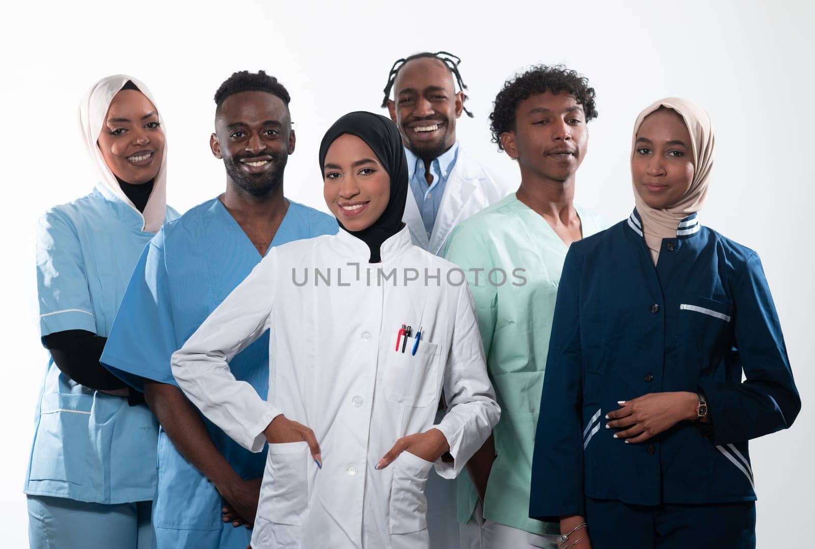 Team or group of a doctor, nurse and medical professional coworkers standing together. Portrait of diverse healthcare workers looking confident. Middle Eastern and African, Muslim medical team. by dotshock