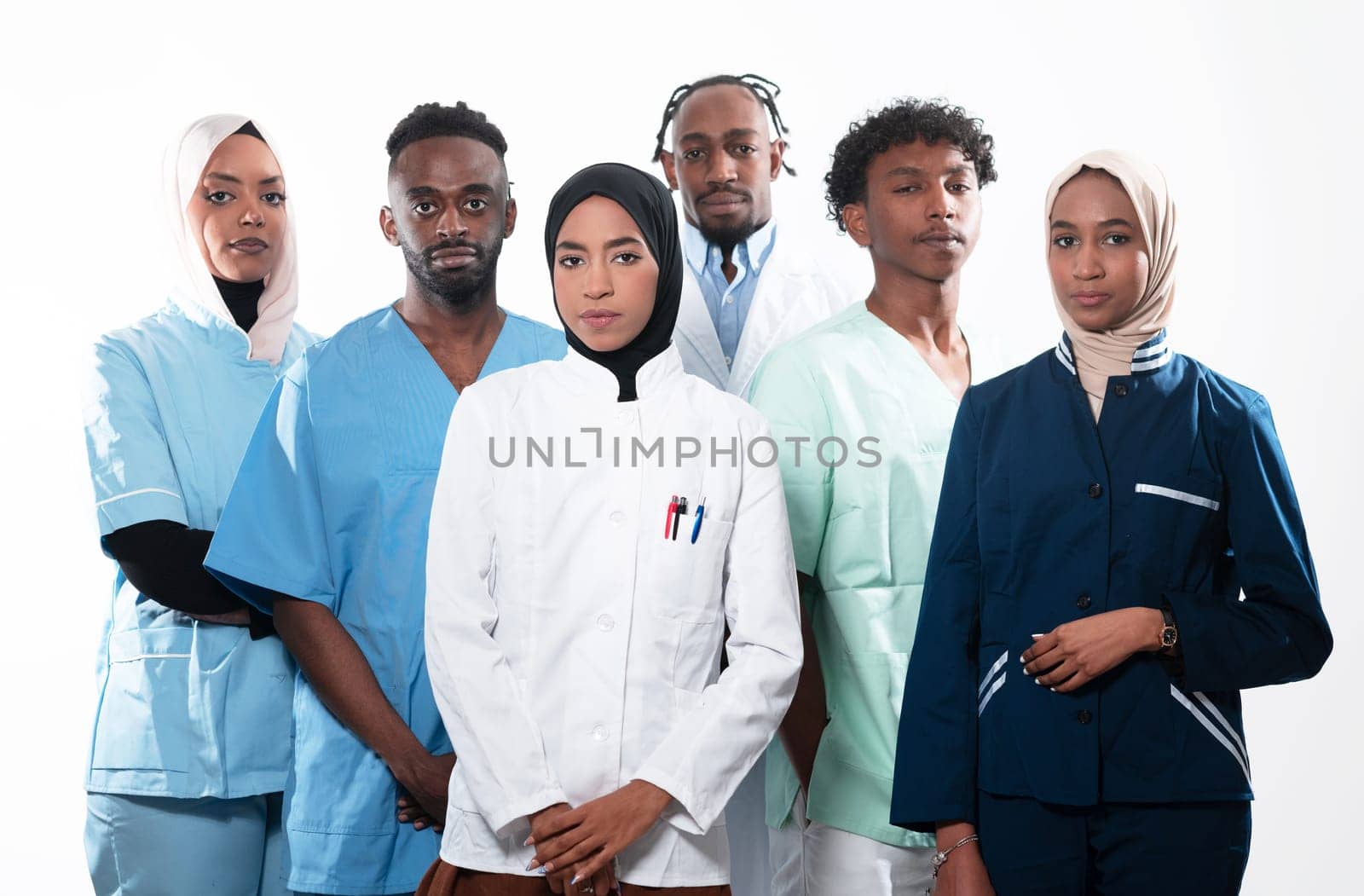 Team or group of a doctor, nurse and medical professional coworkers standing together. Portrait of diverse healthcare workers looking confident. Middle Eastern and African, Muslim medical team. by dotshock