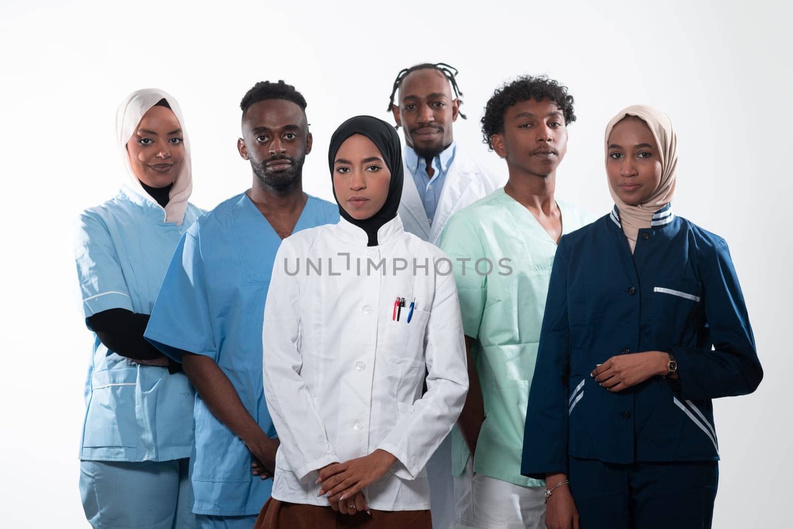 Team or group of a doctor, nurse and medical professional coworkers standing together. Portrait of diverse healthcare workers looking confident. Middle Eastern and African, Muslim medical team. High quality photo