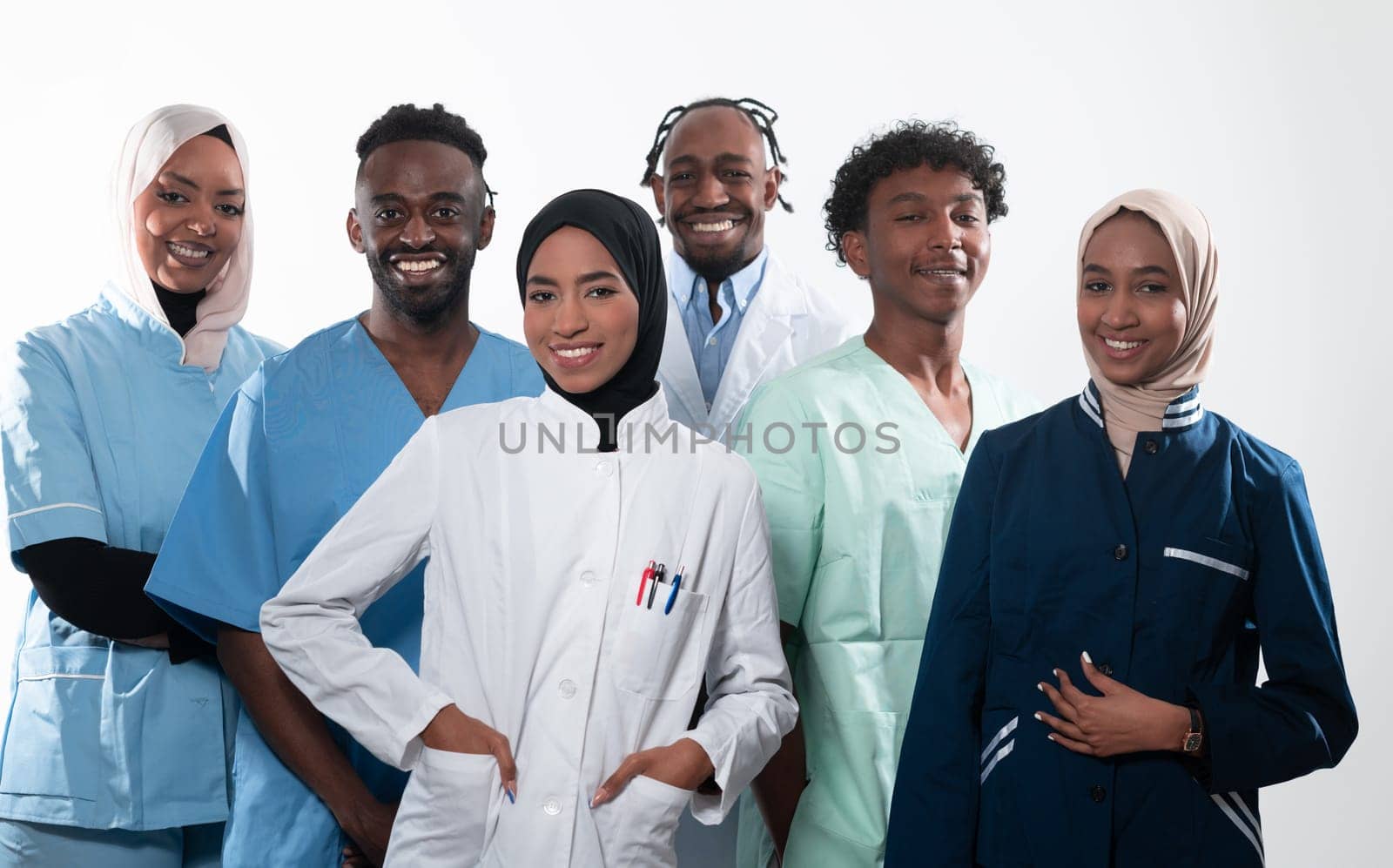 Team or group of a doctor, nurse and medical professional coworkers standing together. Portrait of diverse healthcare workers looking confident. Middle Eastern and African, Muslim medical team. by dotshock