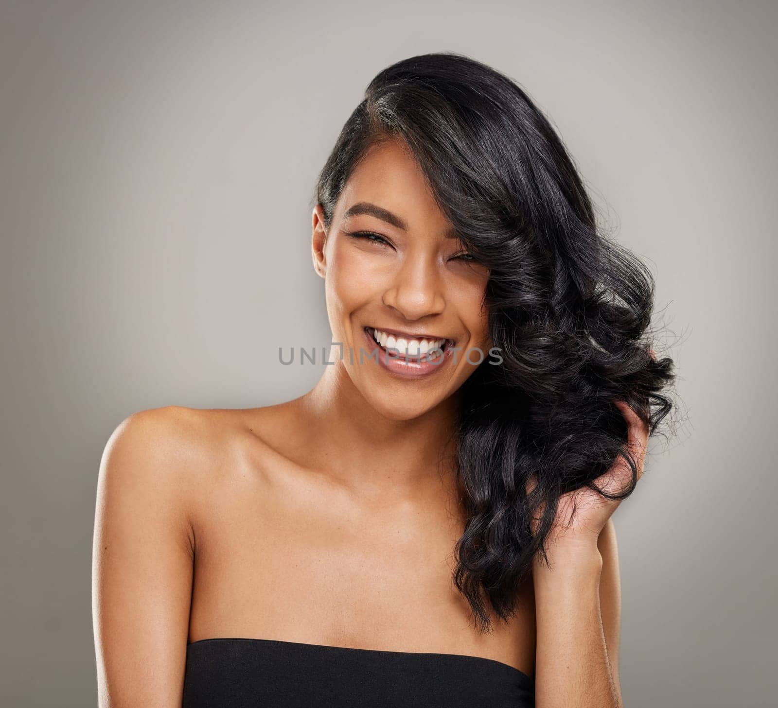 Haircare, beauty and portrait of happy woman in studio for cosmetics, treatment and shine on grey background. Hair, face and satisfied female model posing with volume, texture and keratin results.