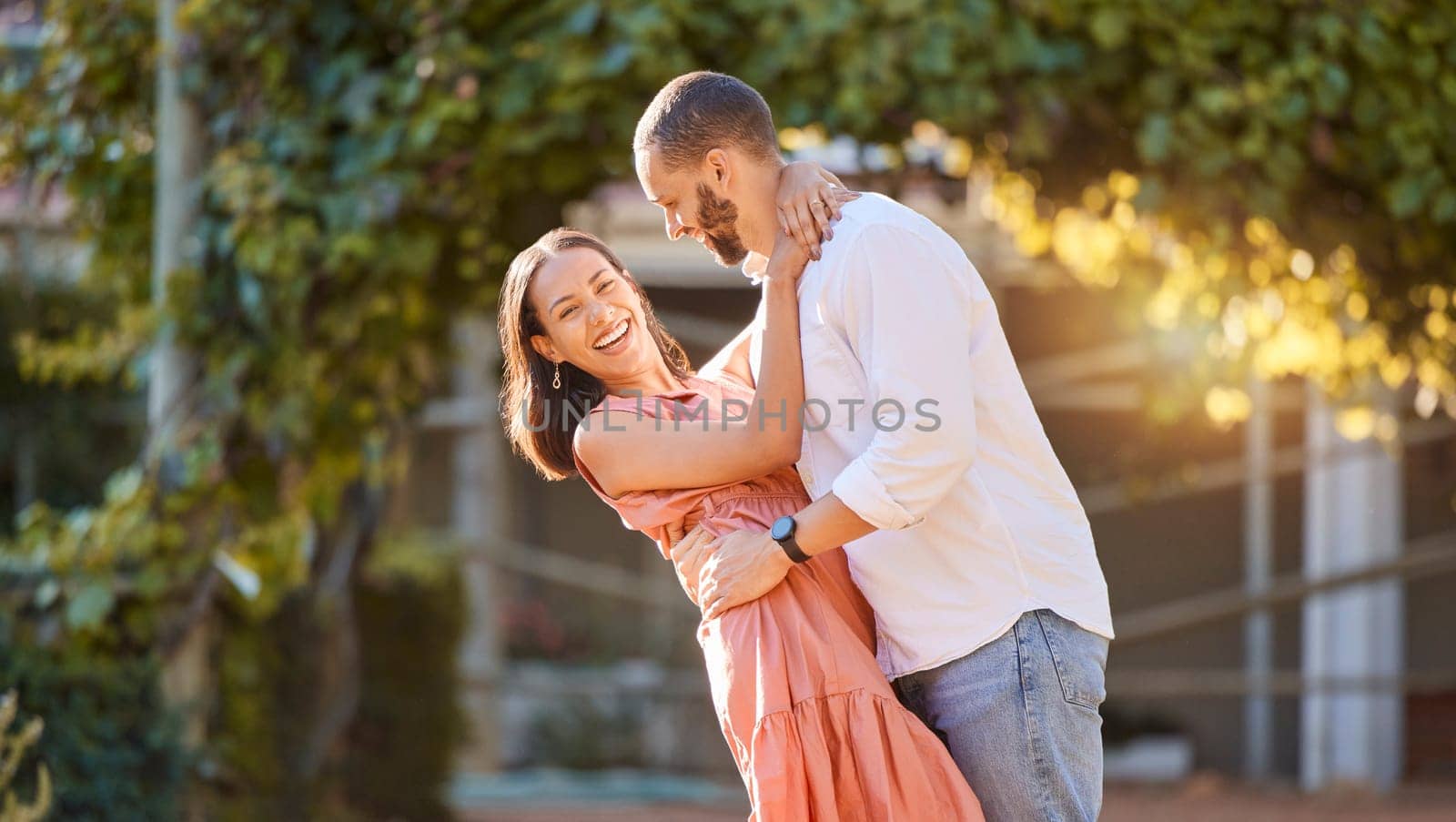 Couple, hug and love in nature park, smile and happy together with relationship and romance on outdoor date. Bonding, care and romantic, man holding woman and spending quality time outside