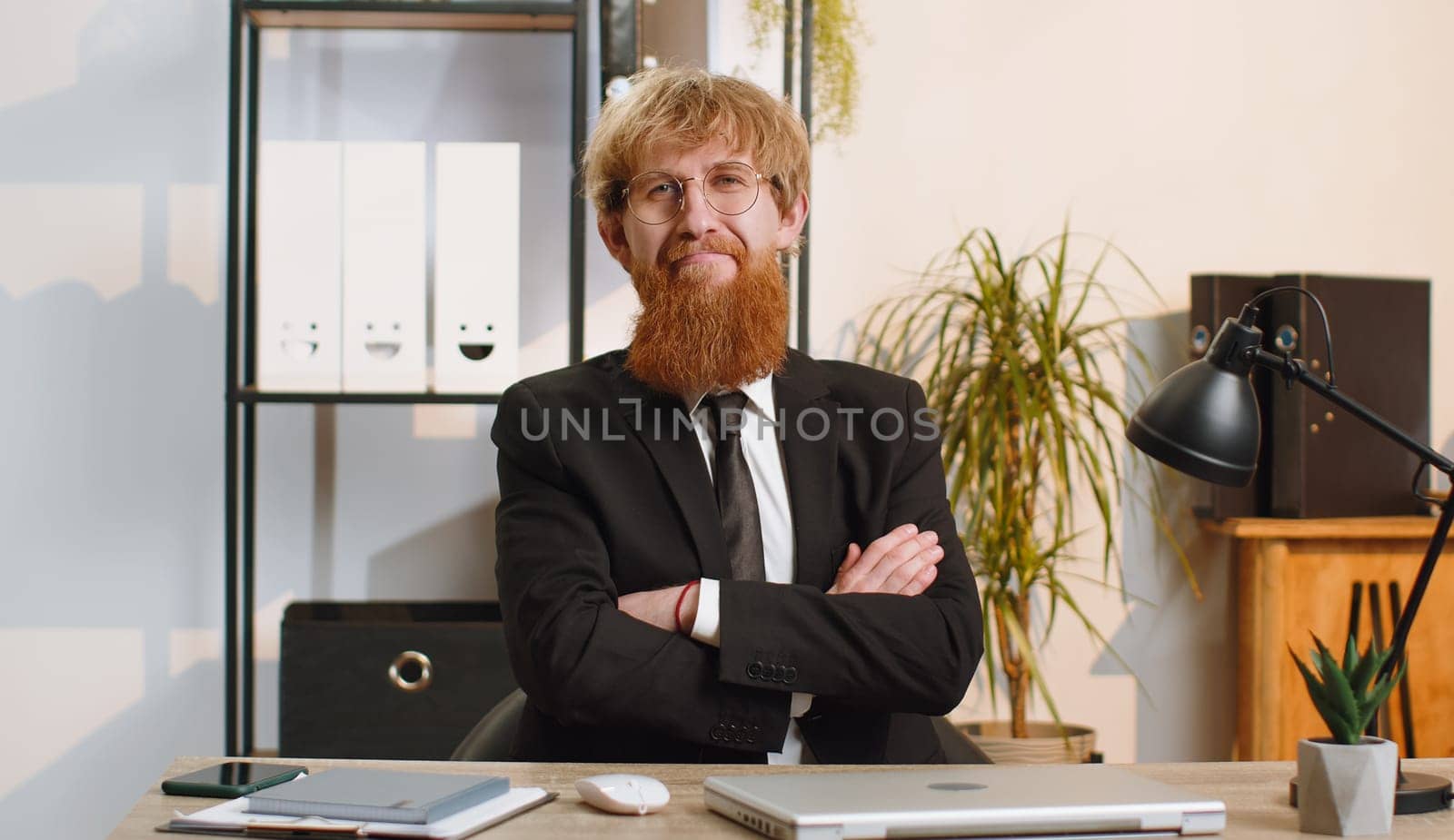 Young businessman sitting at home office workplace desk closing laptop pc after finishing work. Bearded man freelancer working online, remote job. E-learning, browsing internet on notebook computer