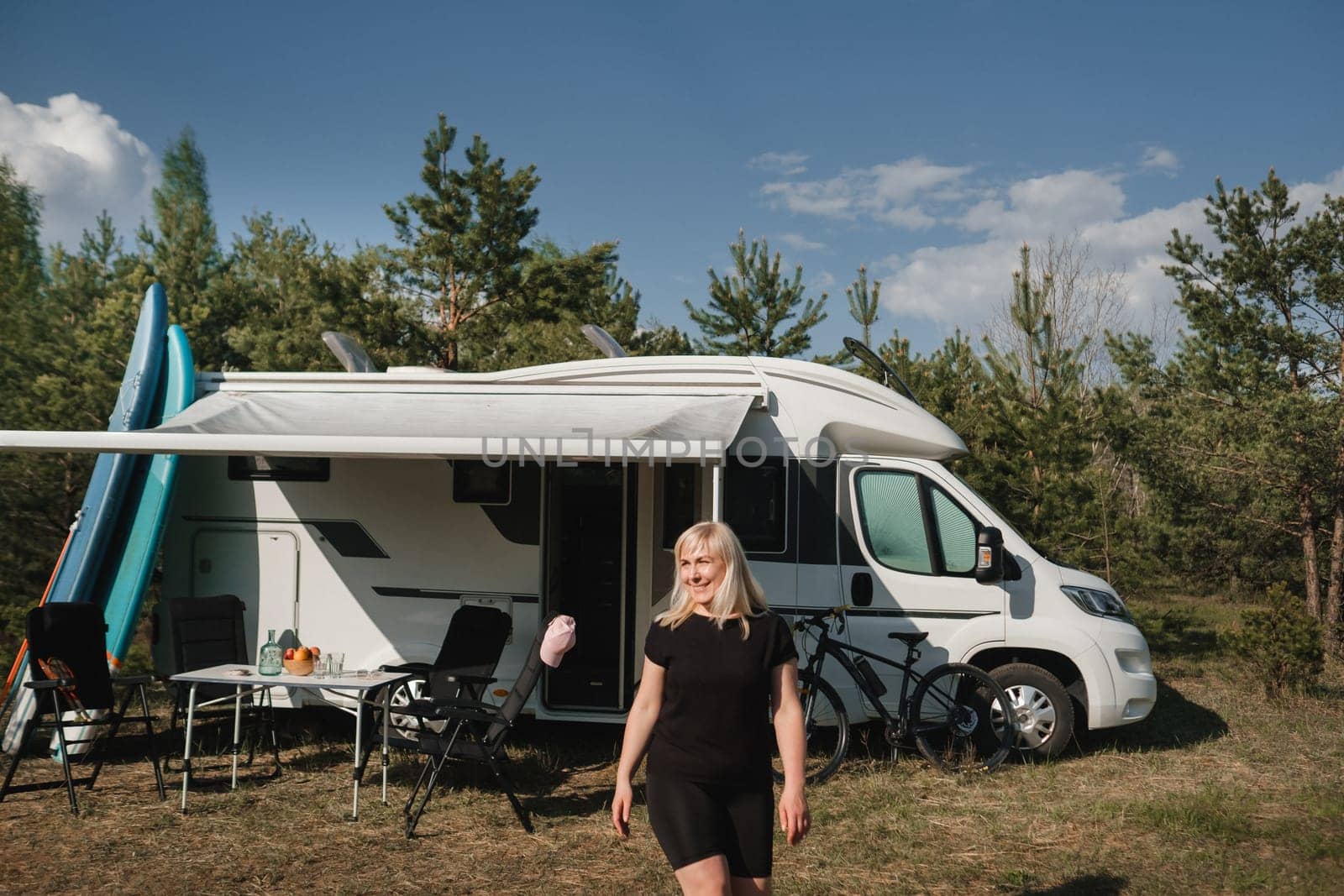 A happy tourist in her motorhome in nature.