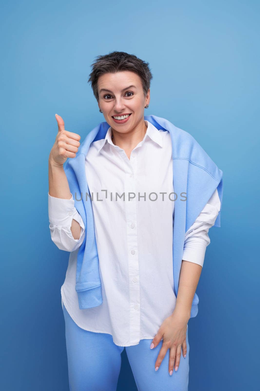 lucky happy young lady with tousled hair in a white shirt in an informal setting.