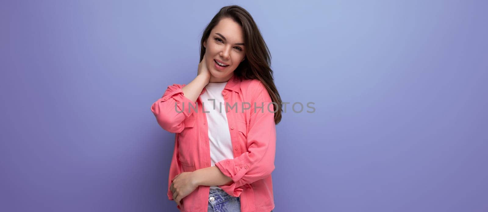portrait of a pretty young black-haired woman in a pink shirt with a Hollywood smile on a studio background by TRMK