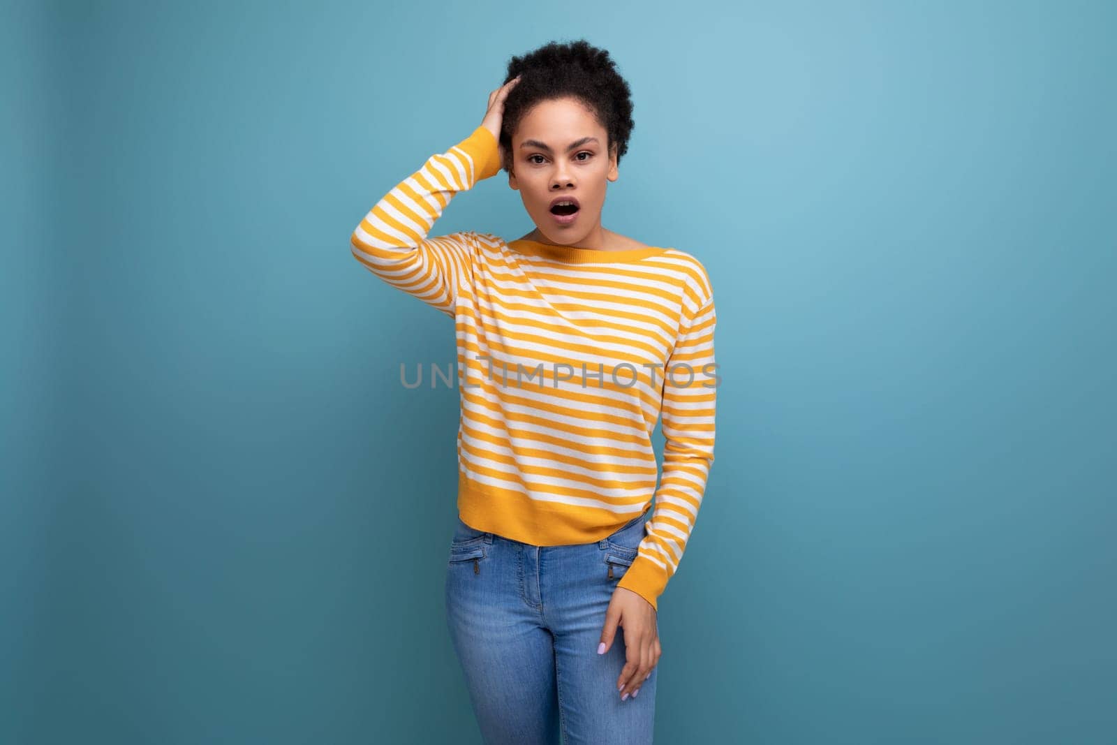 models latina young lady with afro curls got insight on studio background.