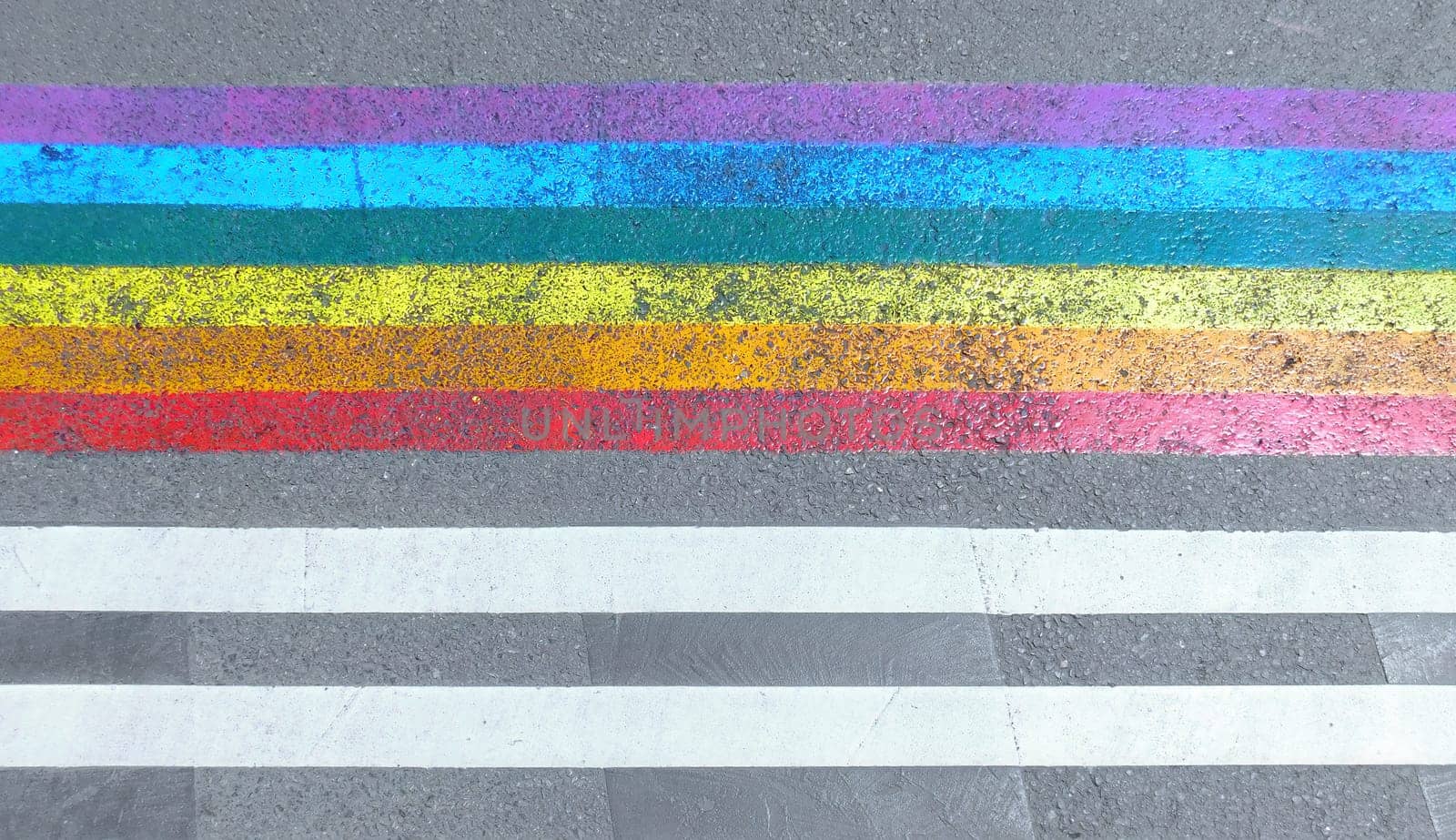 Marked crosswalk with lbgtq pride flag rainbow stripes by Whatawin