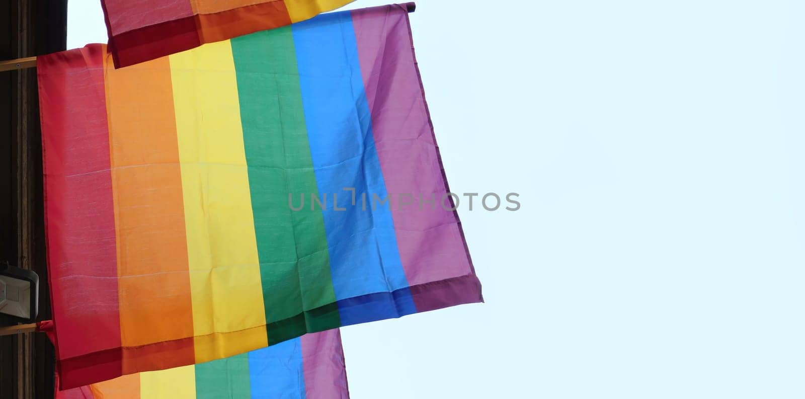 The rainbow flag, gay pride or LGBTQ symbol on light sky background by Whatawin