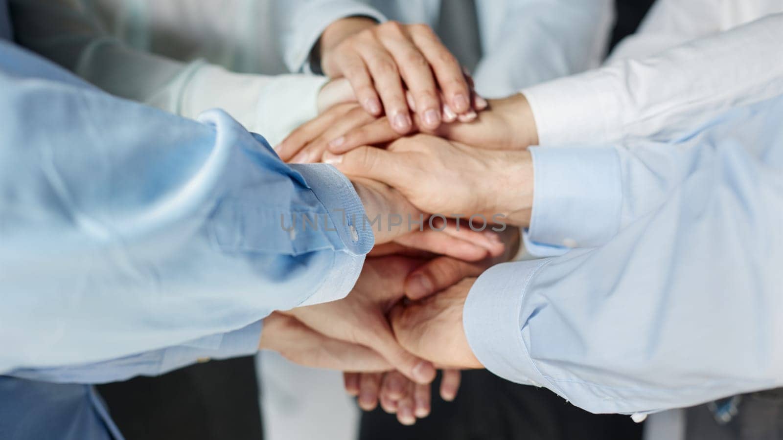 Top view shot of stack of hands. Young college students putting their hands on top of each other symbolizing unity and teamwork.