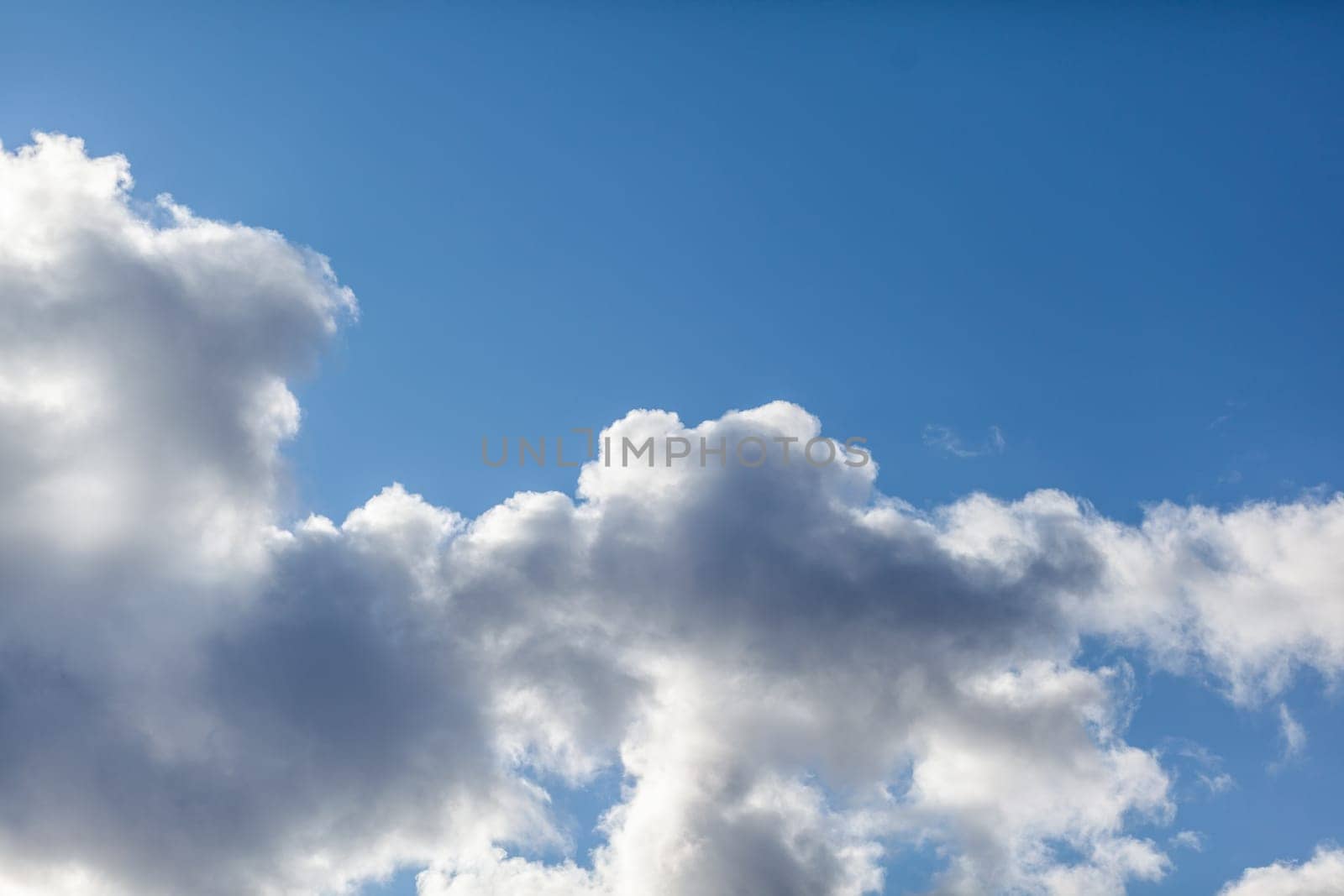 Big white clouds in a blue sky close-up. There is a place for the text. The concept of cleanliness in nature and caring for nature