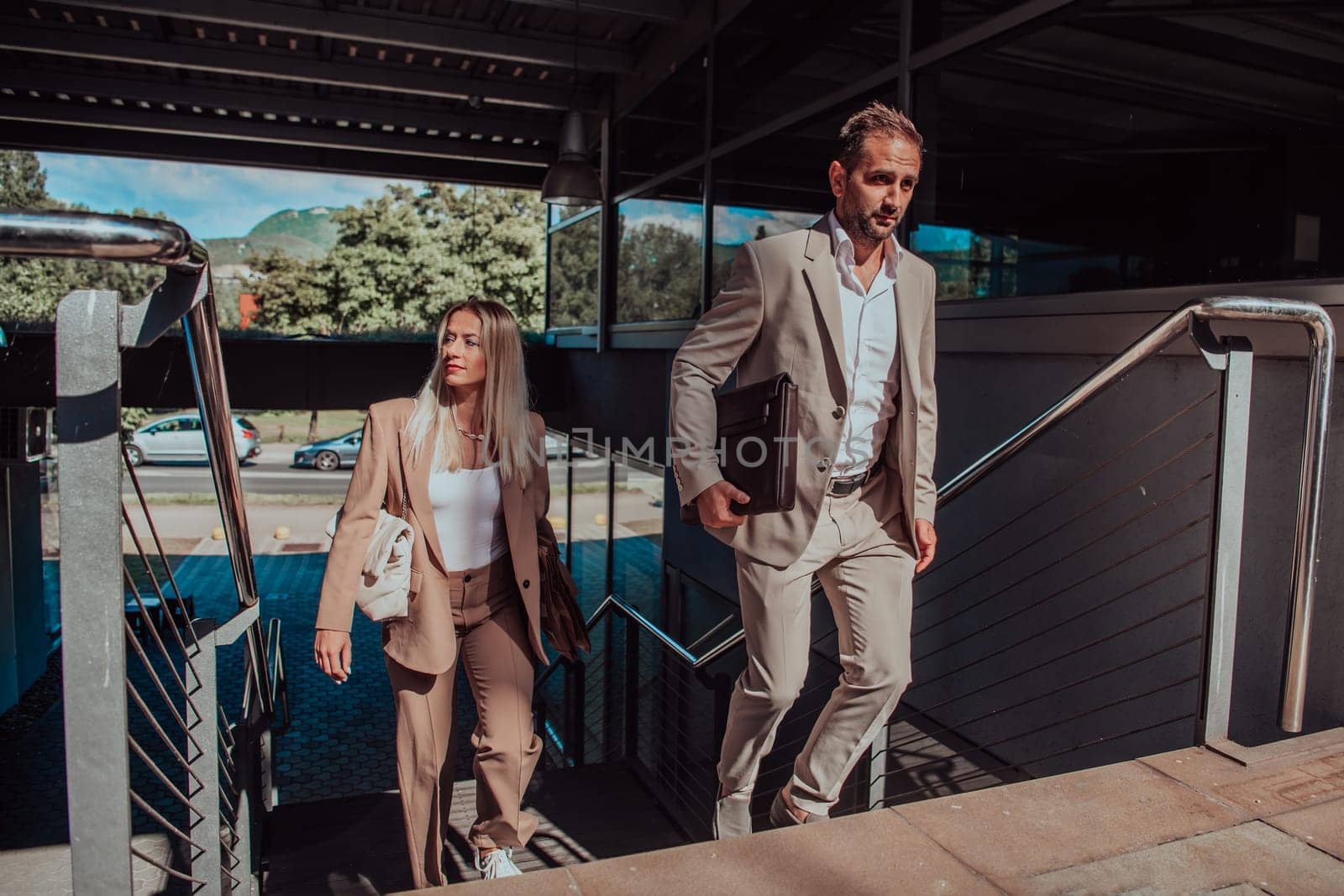 Modern business couple after a long day's work, walking together towards the comfort of their home, embodying the perfect blend of professional success and personal contentment. by dotshock