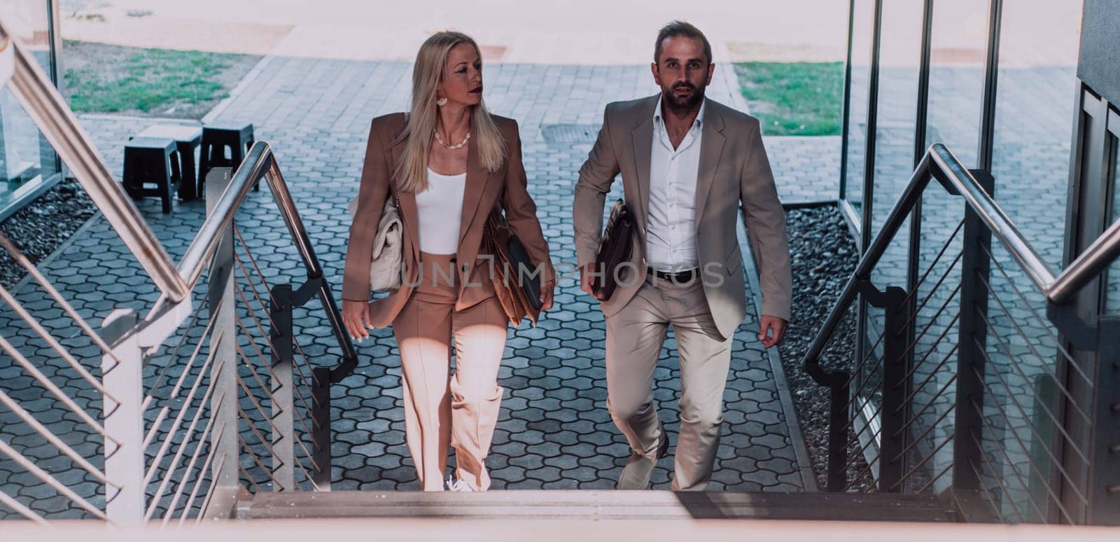 Modern business couple after a long day's work, walking together towards the comfort of their home, embodying the perfect blend of professional success and personal contentment