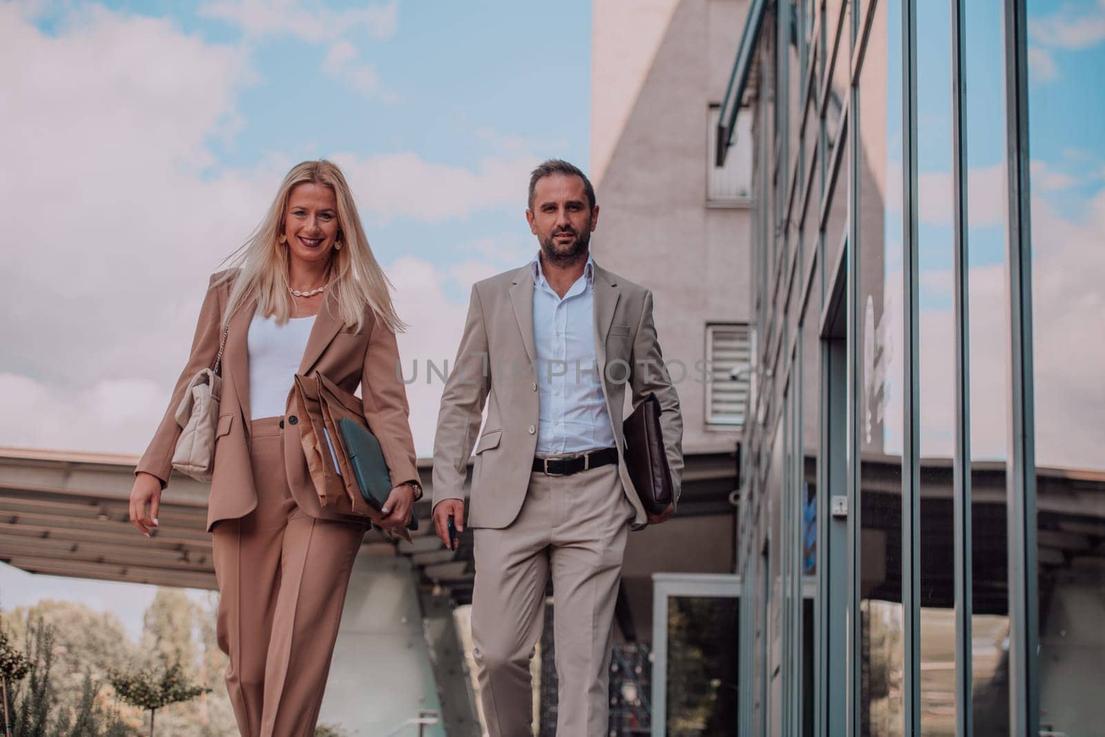 Modern business couple after a long day's work, walking together towards the comfort of their home, embodying the perfect blend of professional success and personal contentment. by dotshock