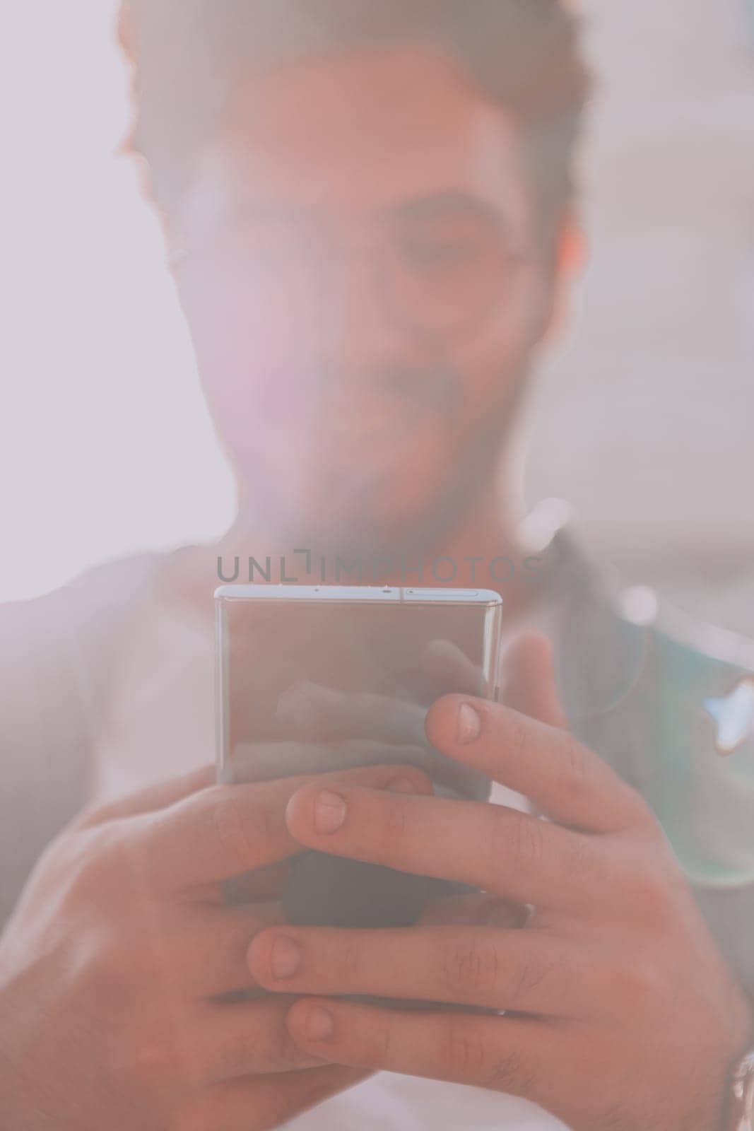 A young man utilizes his smartphone outdoors, showcasing the seamless integration of technology and mobility in modern professional life. by dotshock