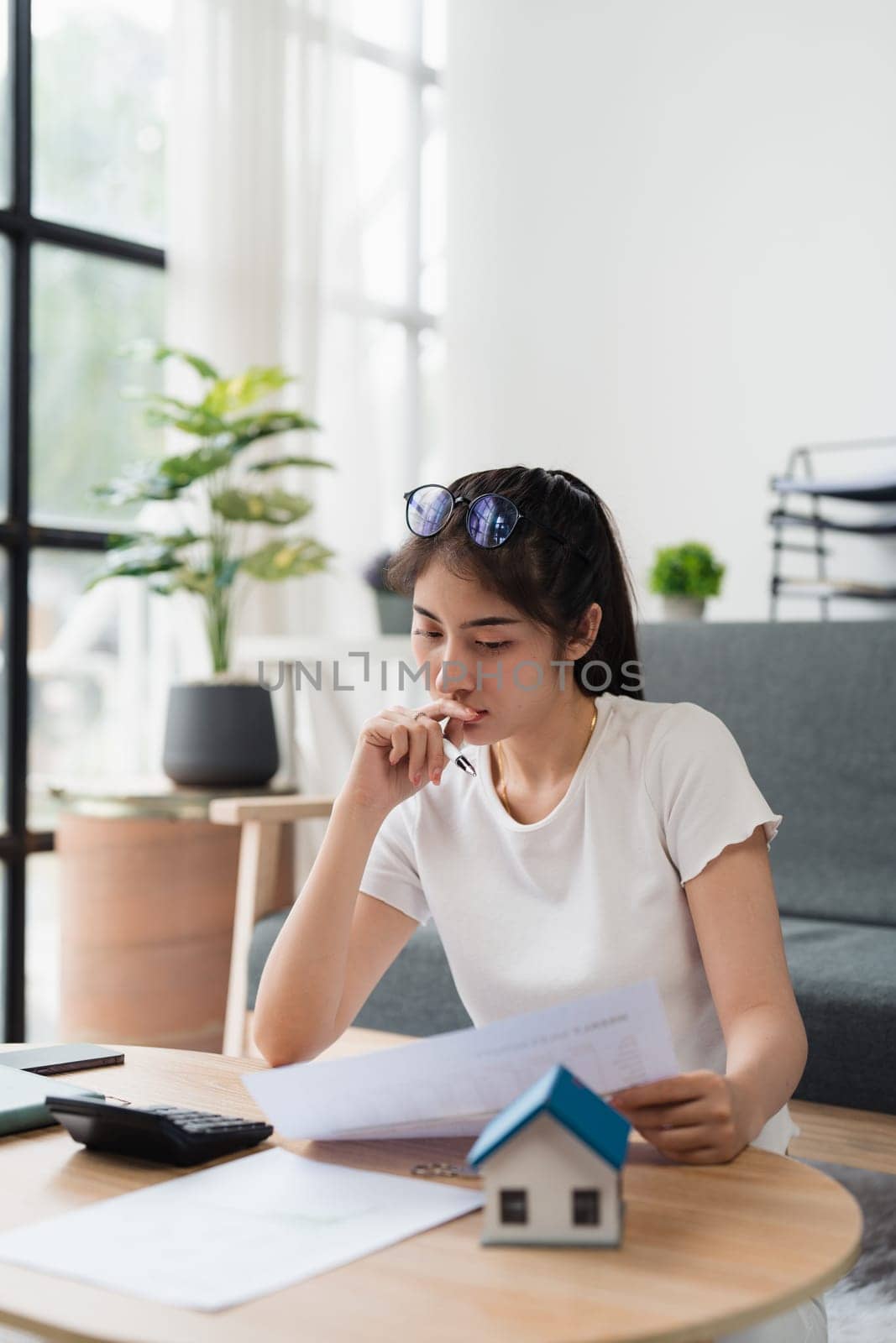 Asian accounting professional calculating household bills, reviewing and analyzing household bills, and filing tax returns.