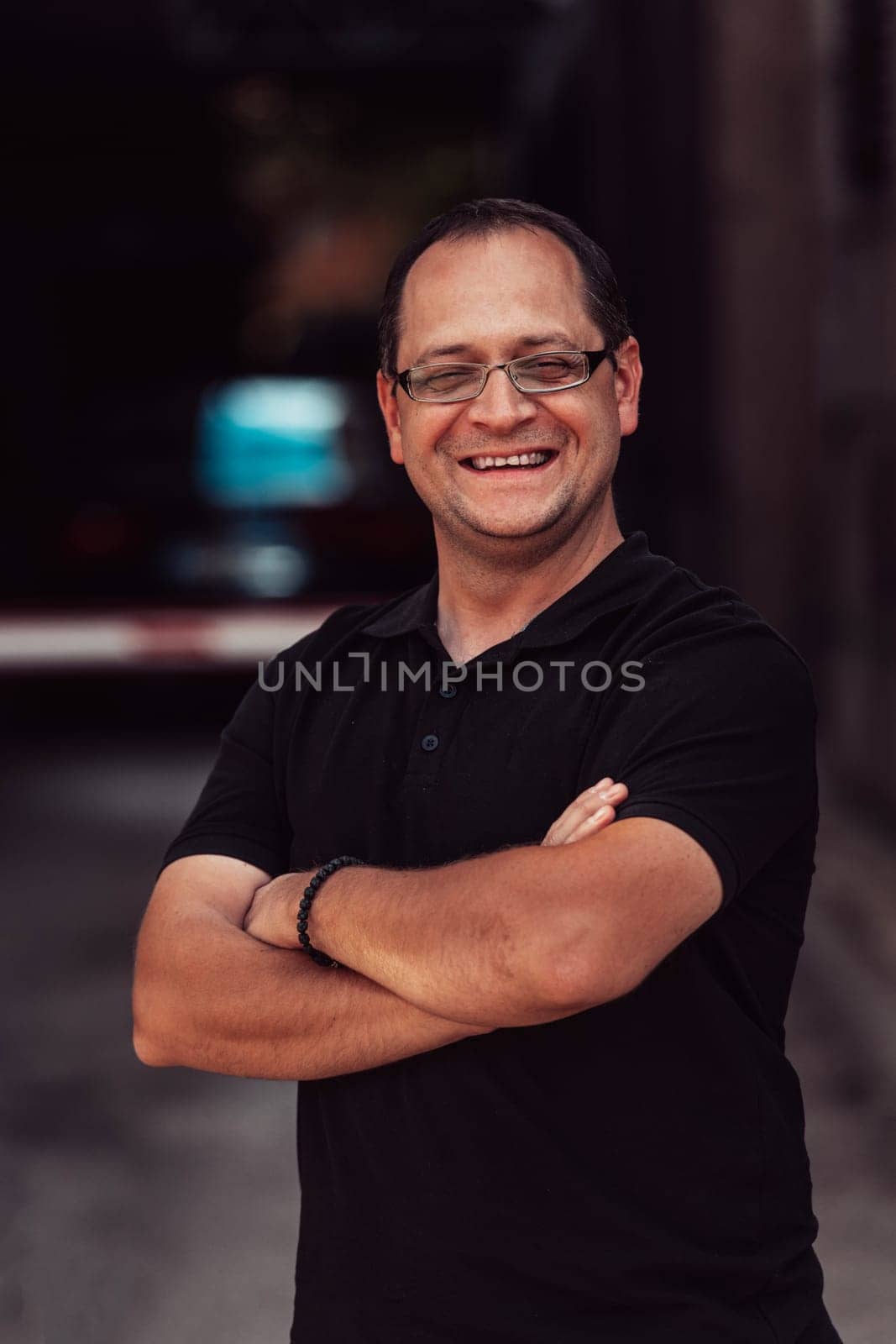 A successful businessman with crossed arms, posing outdoors by dotshock