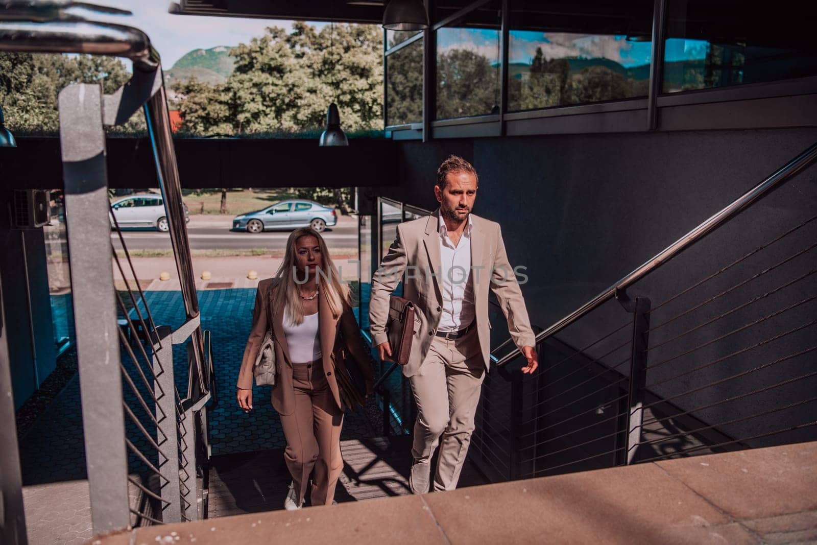 Modern business couple after a long day's work, walking together towards the comfort of their home, embodying the perfect blend of professional success and personal contentment. by dotshock