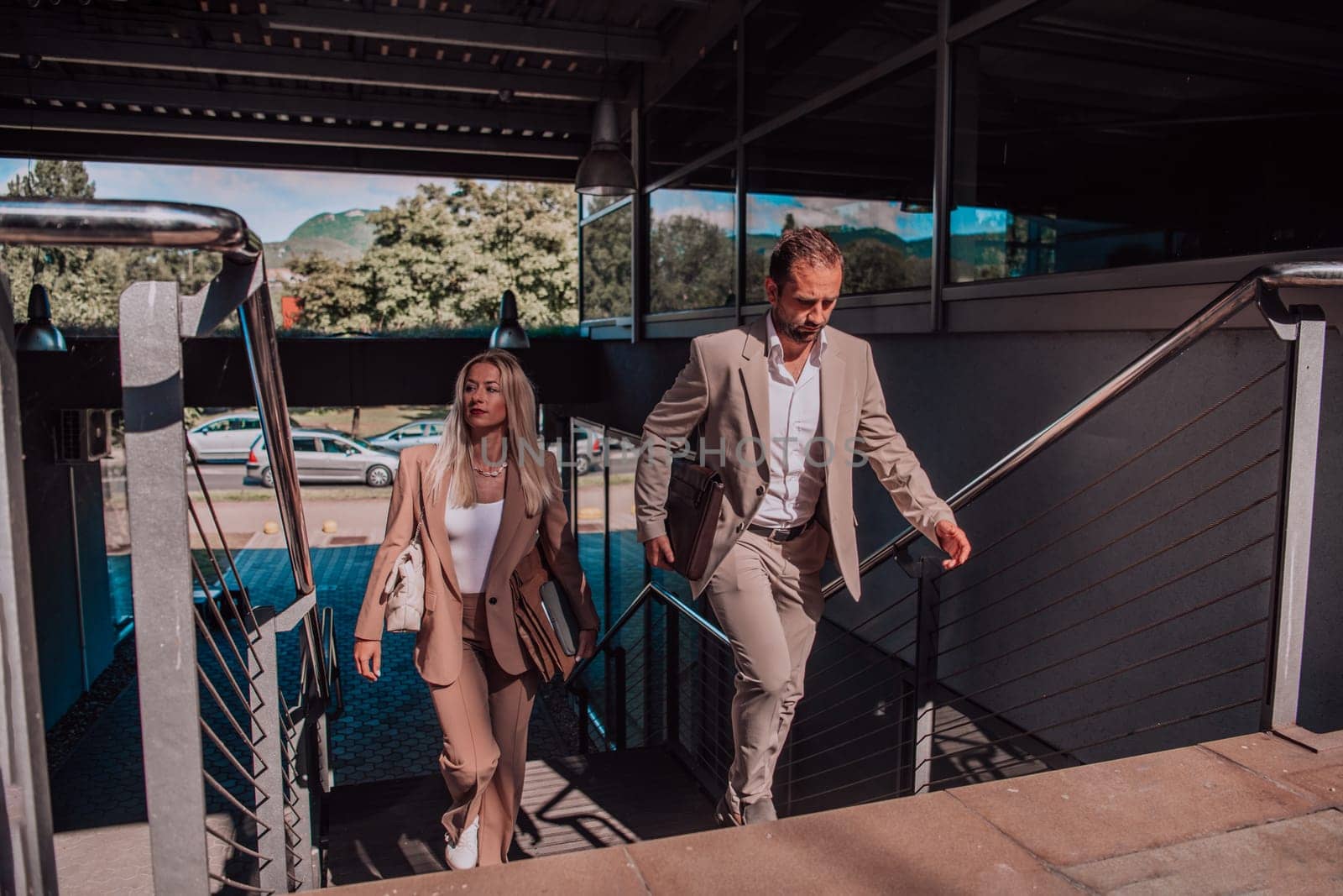 Modern business couple after a long day's work, walking together towards the comfort of their home, embodying the perfect blend of professional success and personal contentment. by dotshock