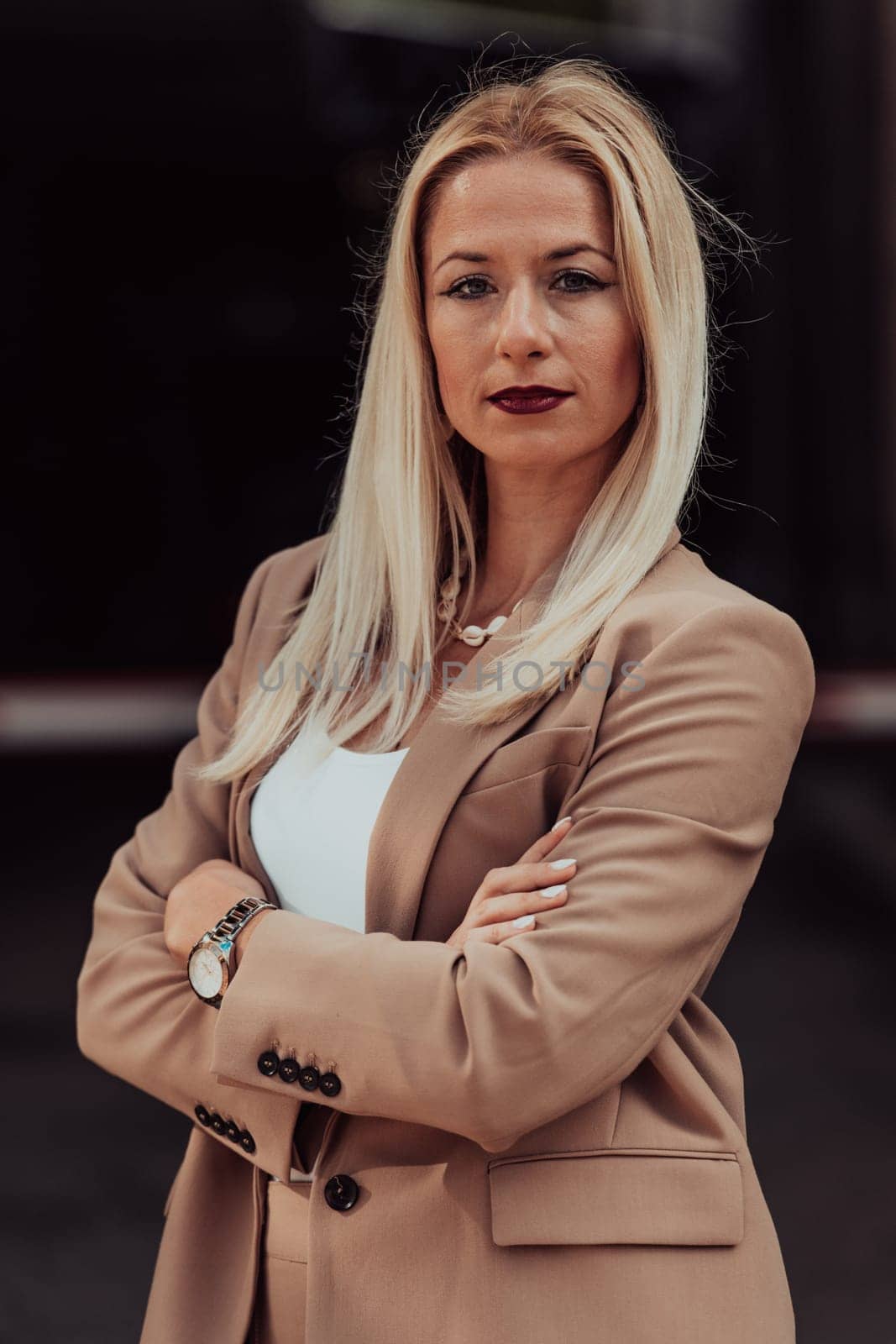 A powerful portrait of a businesswoman, standing confidently with her arms crossed, representing the determination of the female gender and embodying strength and success.