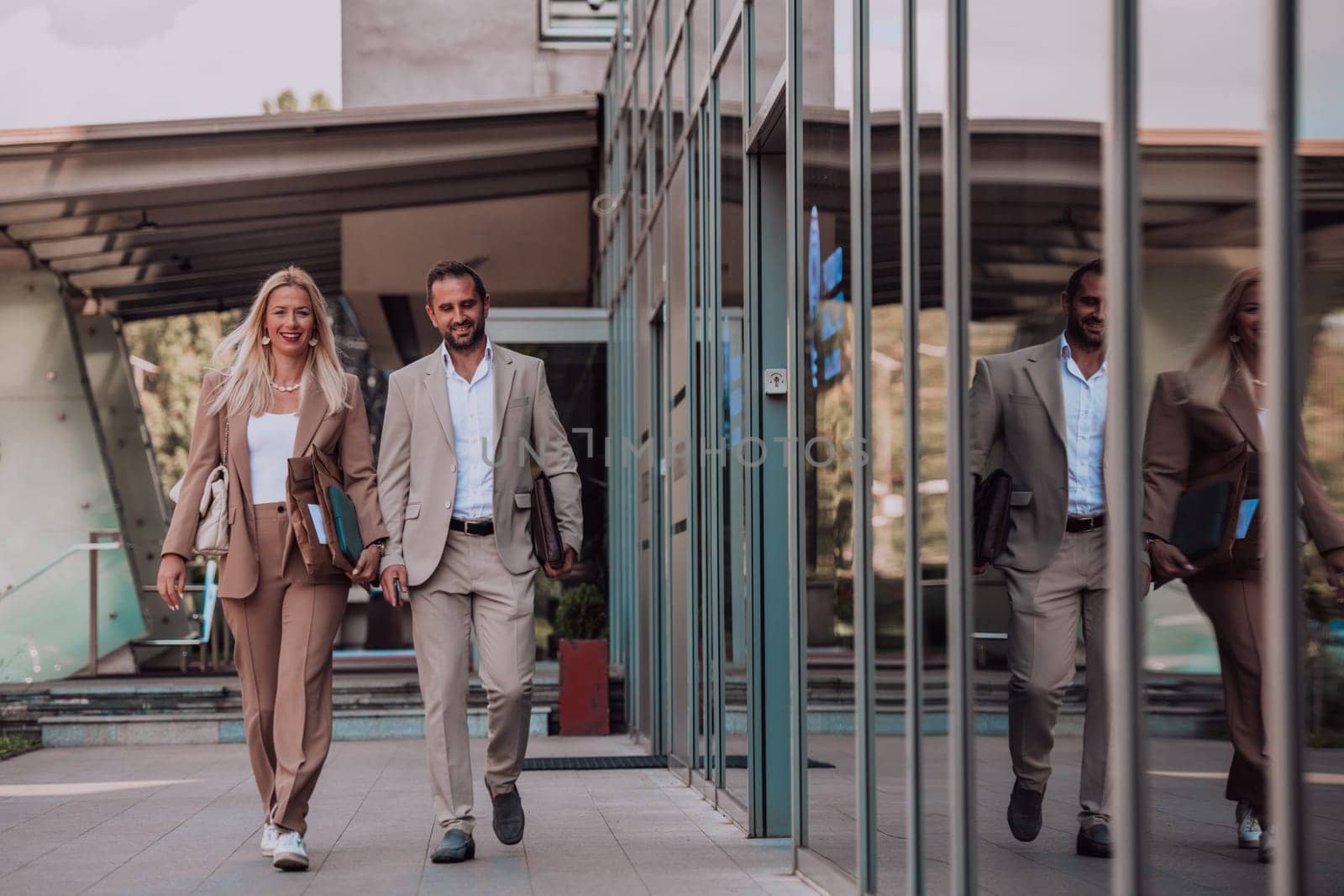 Modern business couple after a long day's work, walking together towards the comfort of their home, embodying the perfect blend of professional success and personal contentment. by dotshock