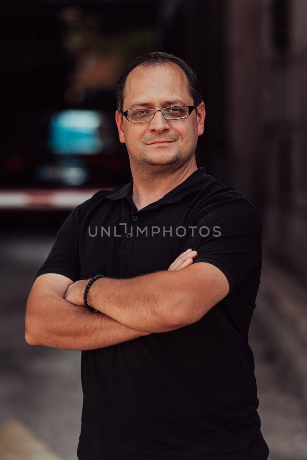A successful businessman with crossed arms, posing outdoors by dotshock