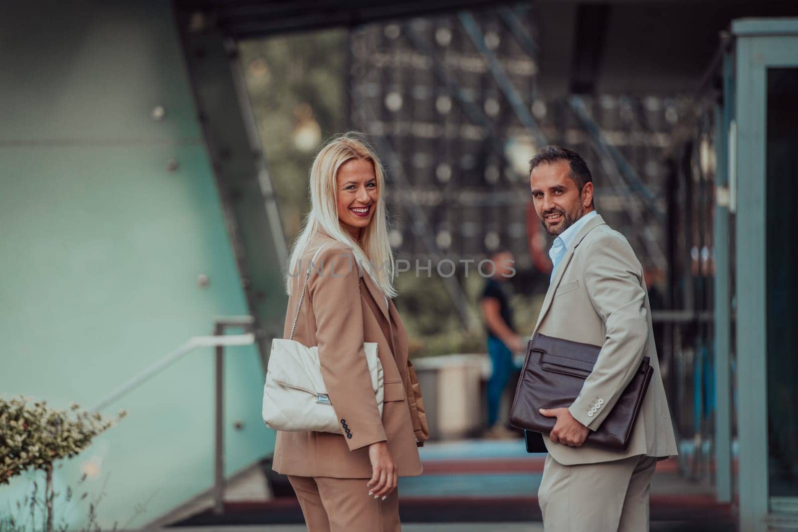 Modern business couple after a long day's work, walking together towards the comfort of their home, embodying the perfect blend of professional success and personal contentment. by dotshock