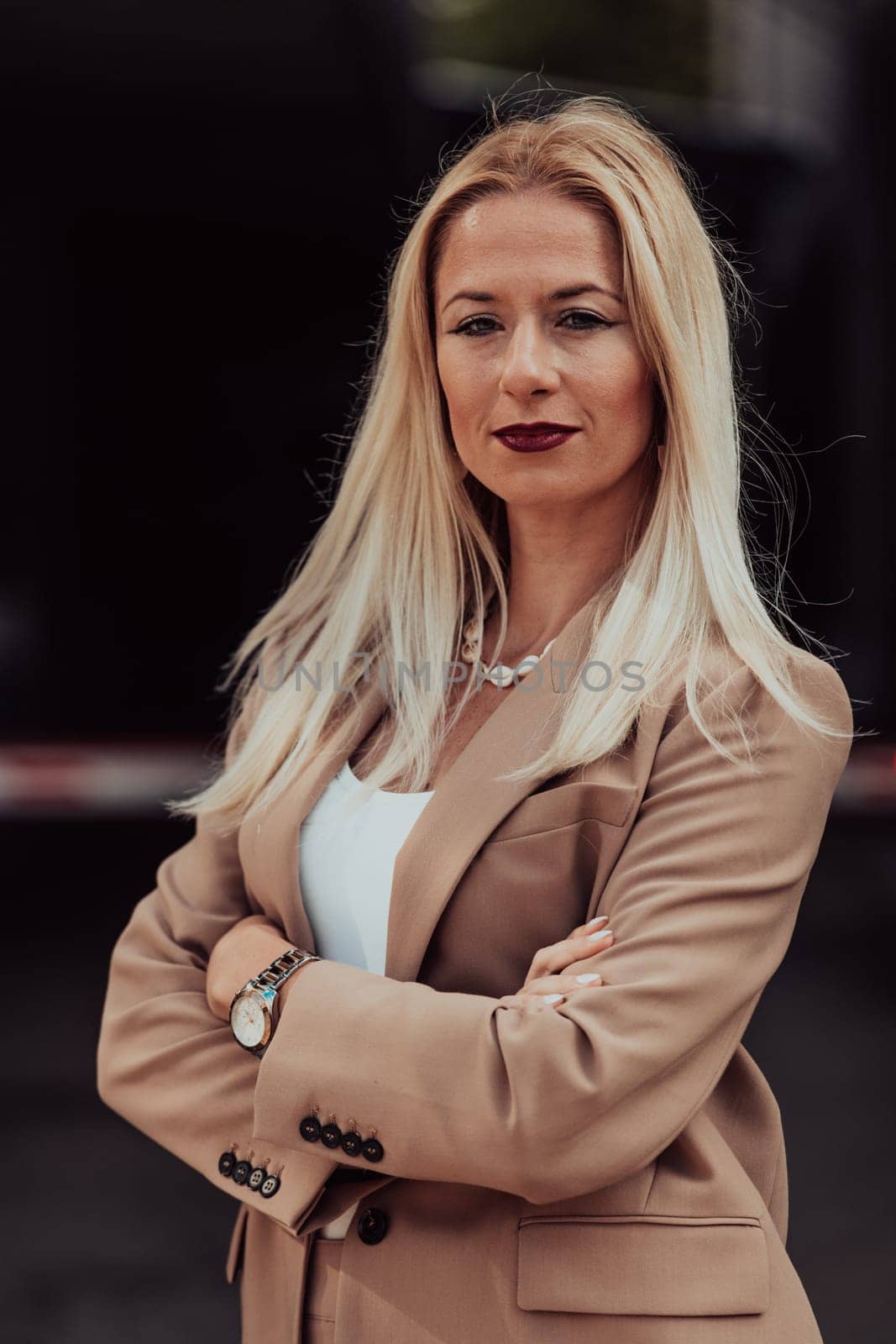 A powerful portrait of a businesswoman, standing confidently with her arms crossed, representing the determination of the female gender and embodying strength and success.