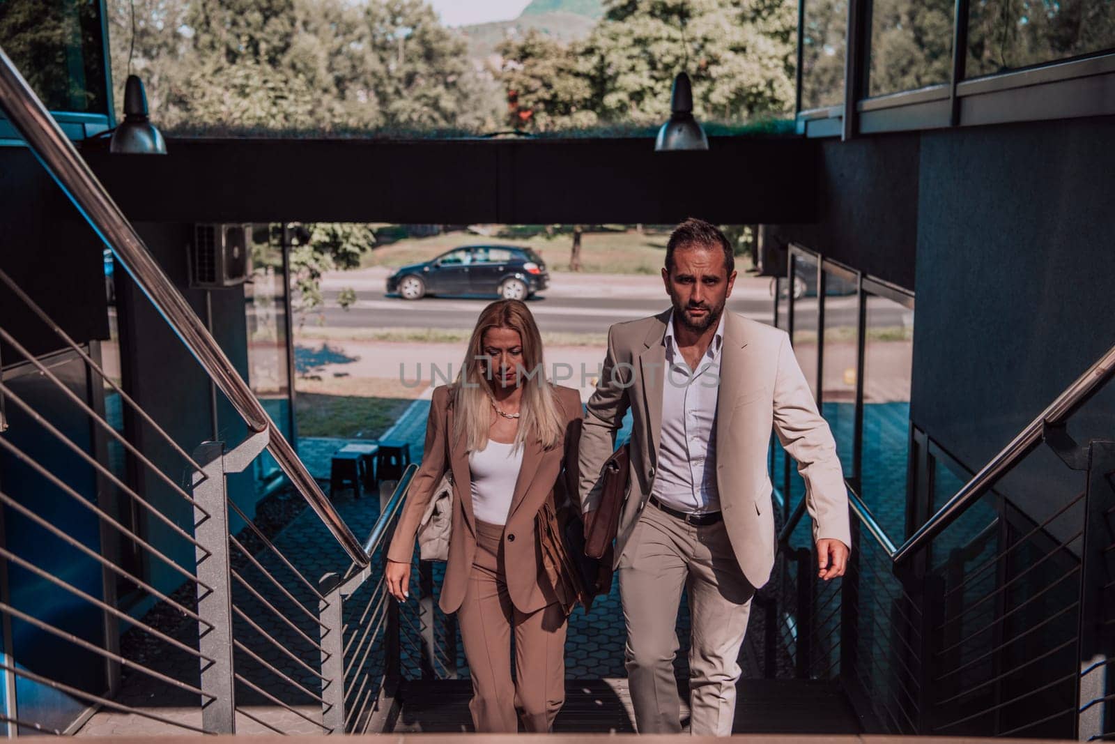 Modern business couple after a long day's work, walking together towards the comfort of their home, embodying the perfect blend of professional success and personal contentment. by dotshock