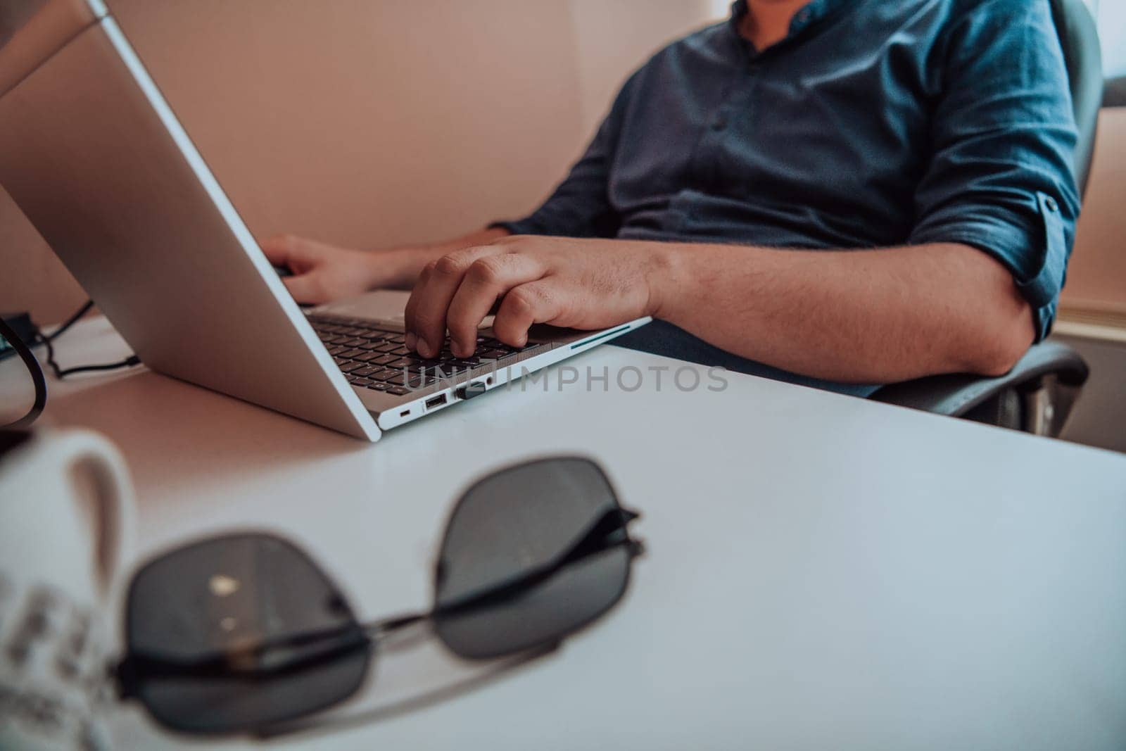 Close-up photo of a programmer typing on a laptop by dotshock