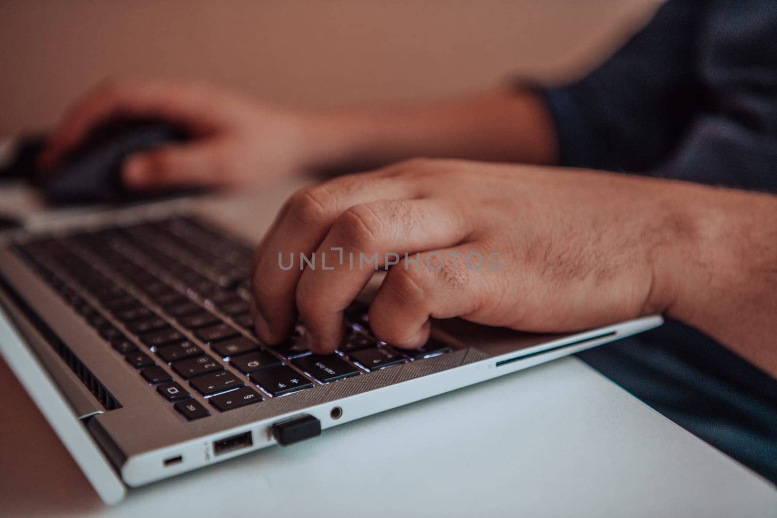 Close-up photo of a programmer typing on a laptop by dotshock