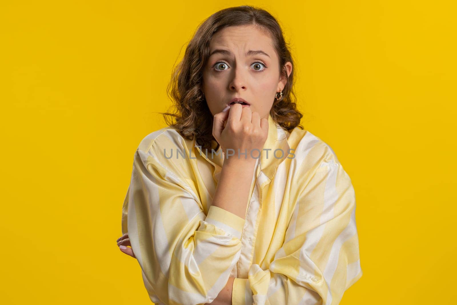Stressed depressed young woman terrified about danger problems, suffering phobia, anxiety disorder, expresses fear, waving no, insecure, stress, panic. Girl isolated on yellow studio background