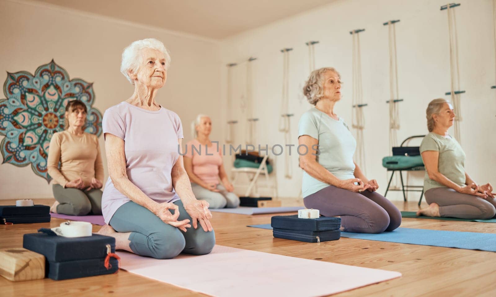 Yoga, lotus and group of senior women in gym meditating for spiritual health and wellness. Meditation, zen chakra and retired females training to relax for mindfulness and peace in fitness center. by YuriArcurs