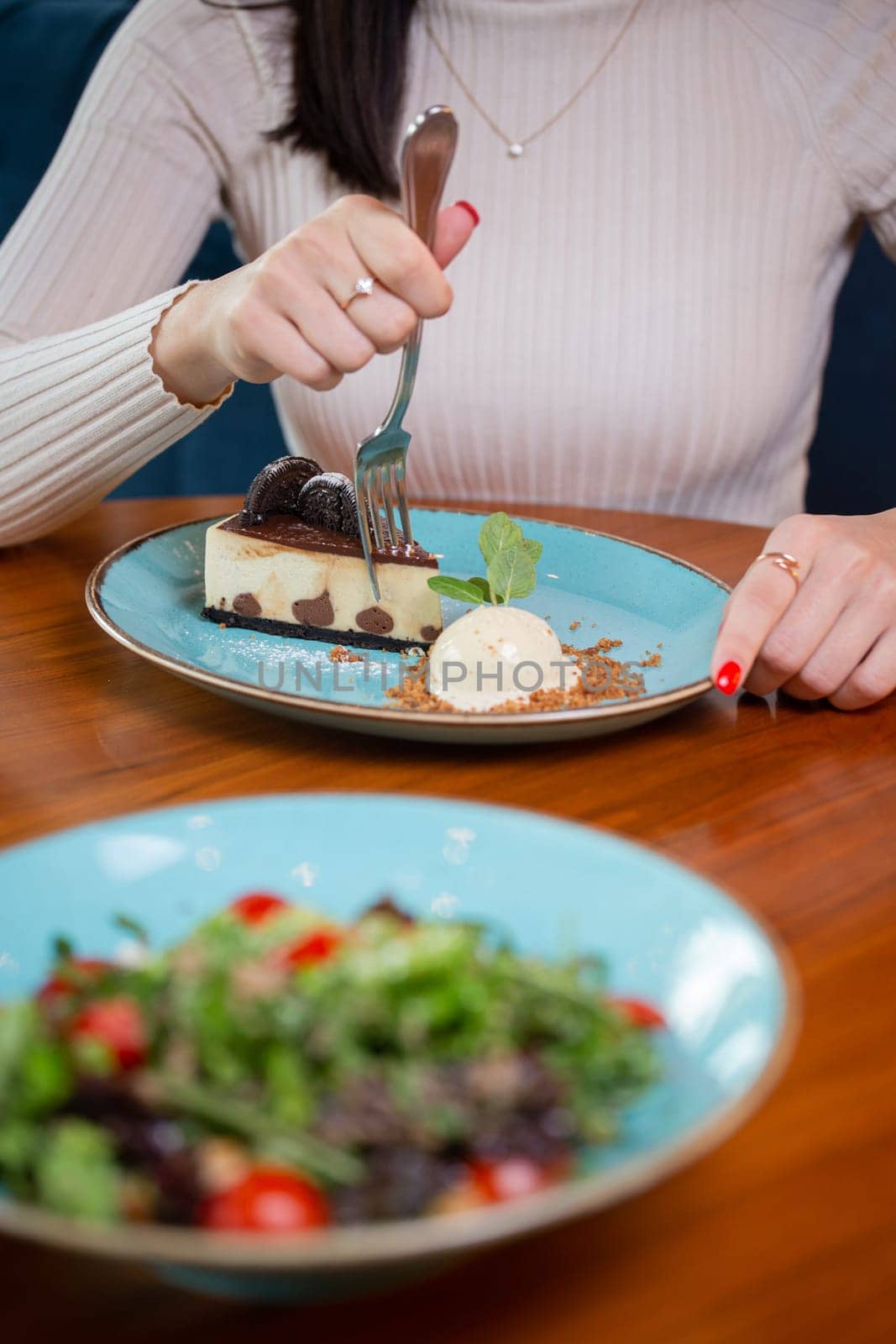 a girl without a face eats dessert in a cafe by Pukhovskiy