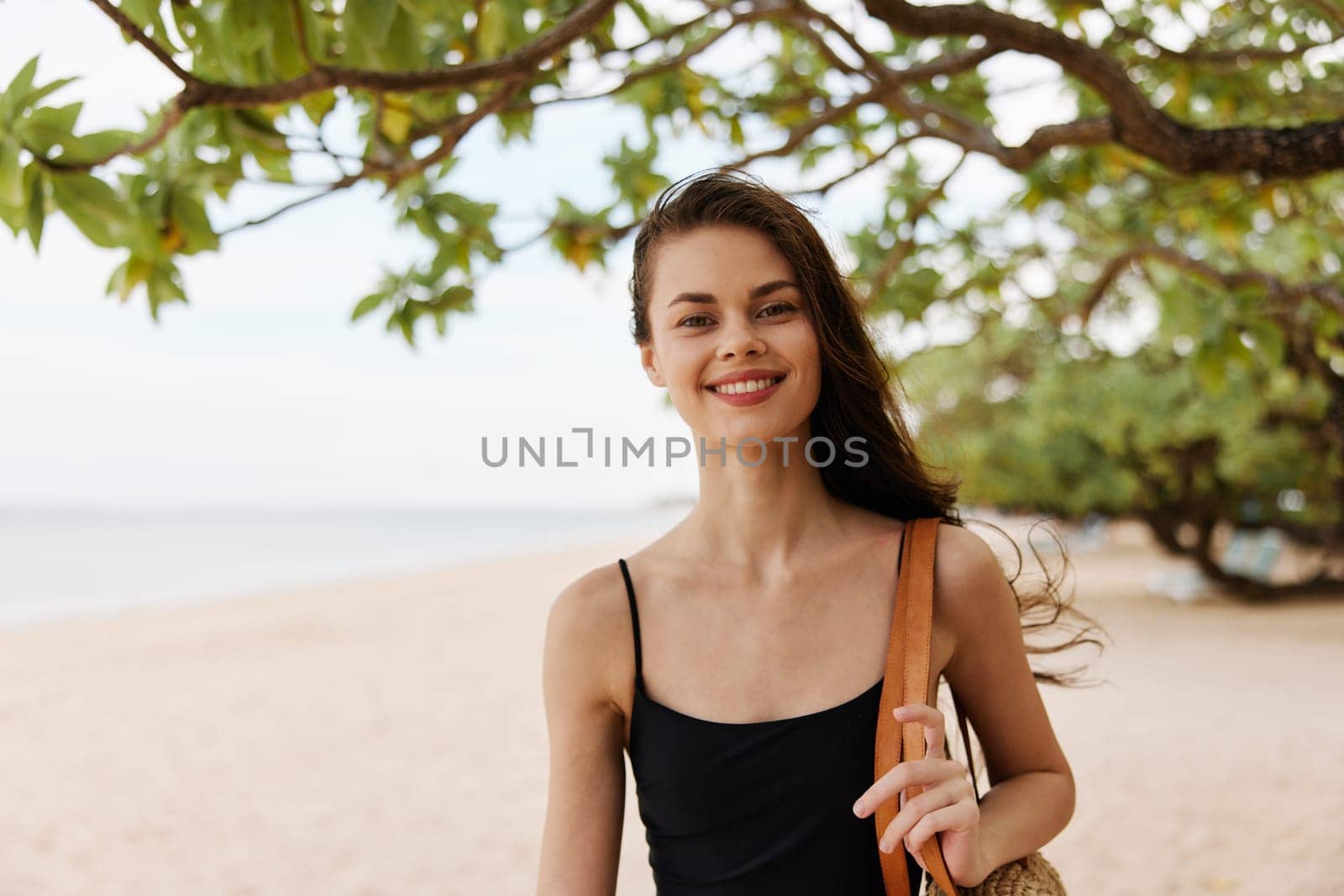 sand woman summer long lifestyle enjoyment sunlight vacation caucasian young peaceful female smile walking copy-space hair sea beach nature ocean bag adult