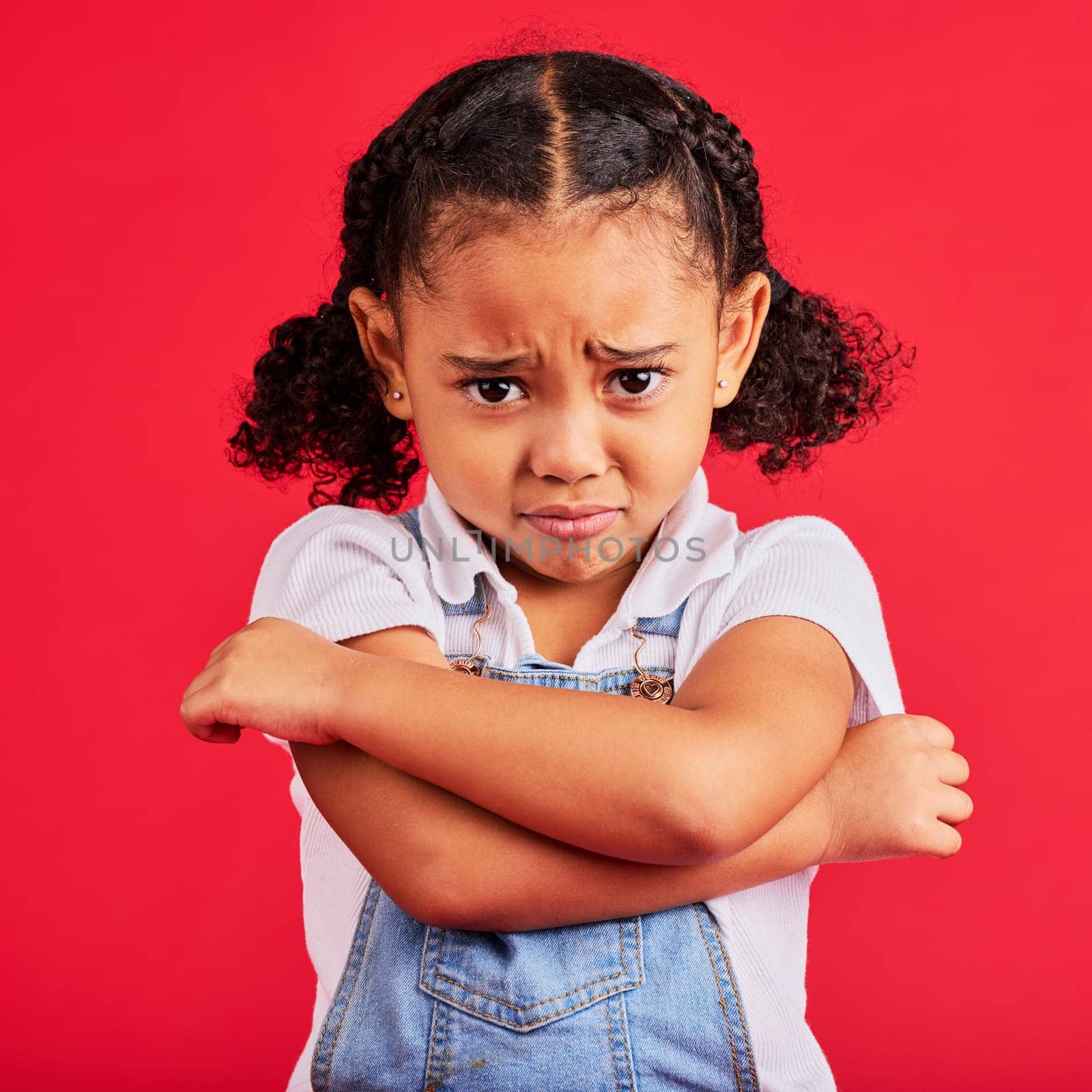 Child, arms crossed or sad portrait on isolated red background for depression, mental health or crying face. Upset, unhappy or little girl with sulking, grumpy or facial expression in bullying crisis.